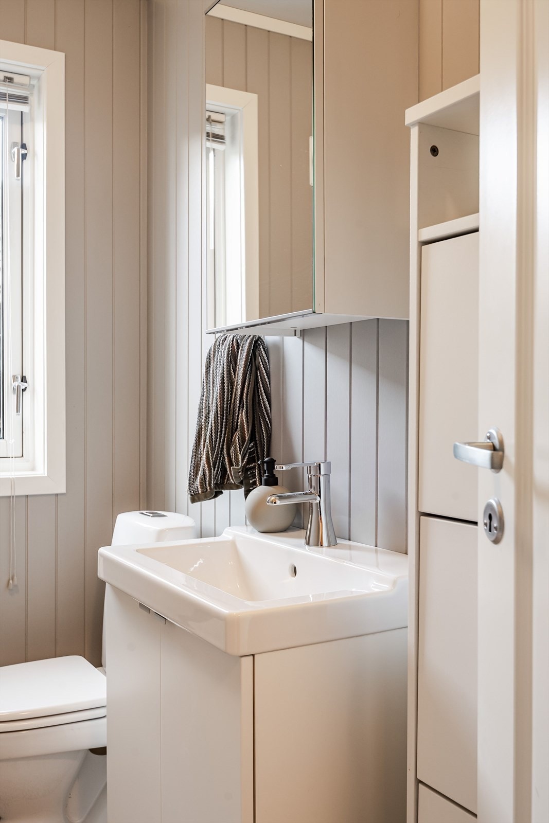 Toalettrommet er utstyrt med servantskap, speilskap, gulvstående toalett og et skoskap. Galleribilde