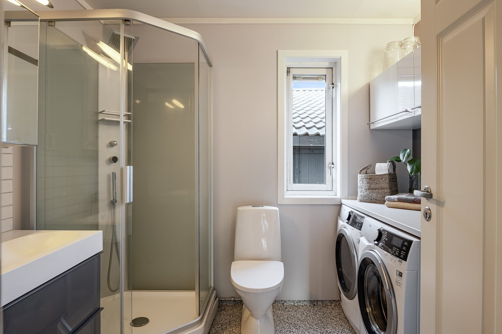 Baderommet er også utstyrt med dusjkabinett med både hånd- og regnfallsdusj, gulvstående toalett og en praktisk vaskeromssone. Galleribilde