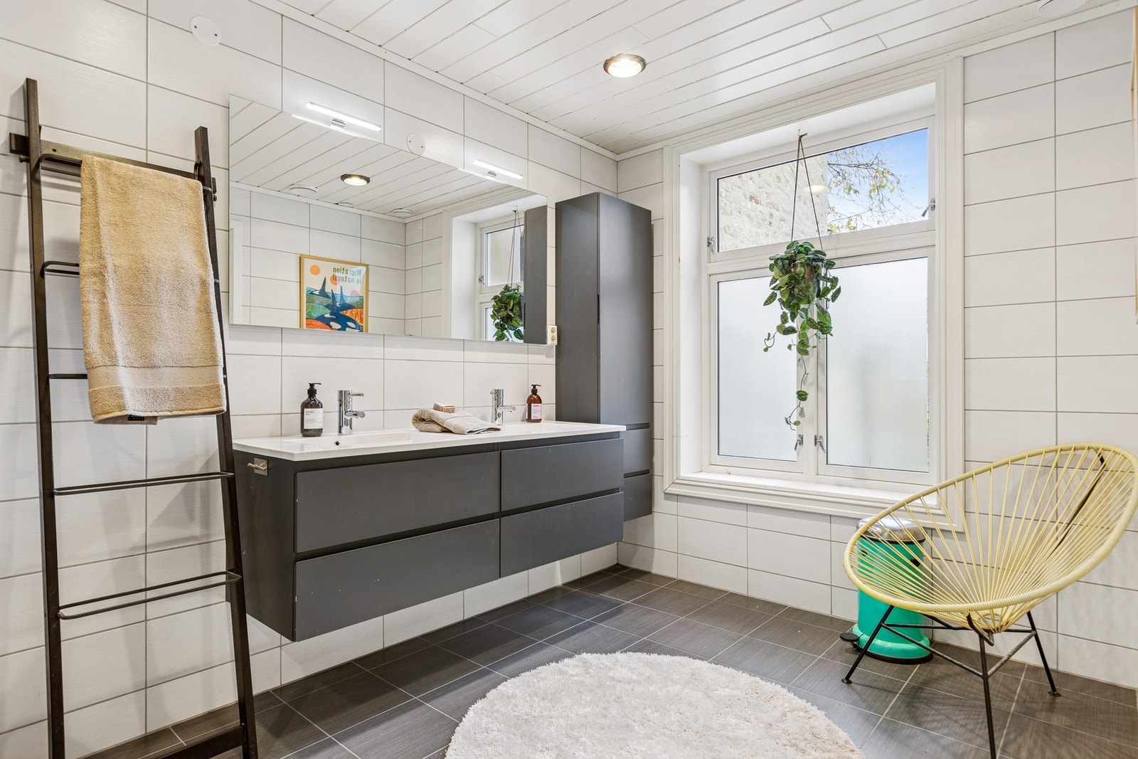 Romslig og lyst bad på 10 kvm, med stilrene fliser og moderne innredning. Galleribilde