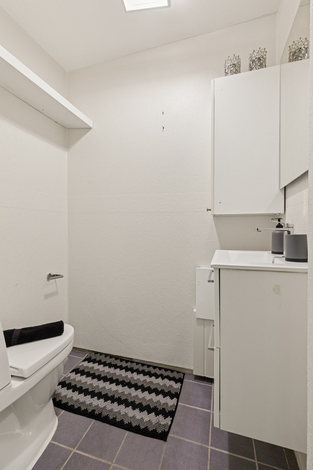 Toalettrommet er innredet med servant med underskap og toalett. Galleribilde