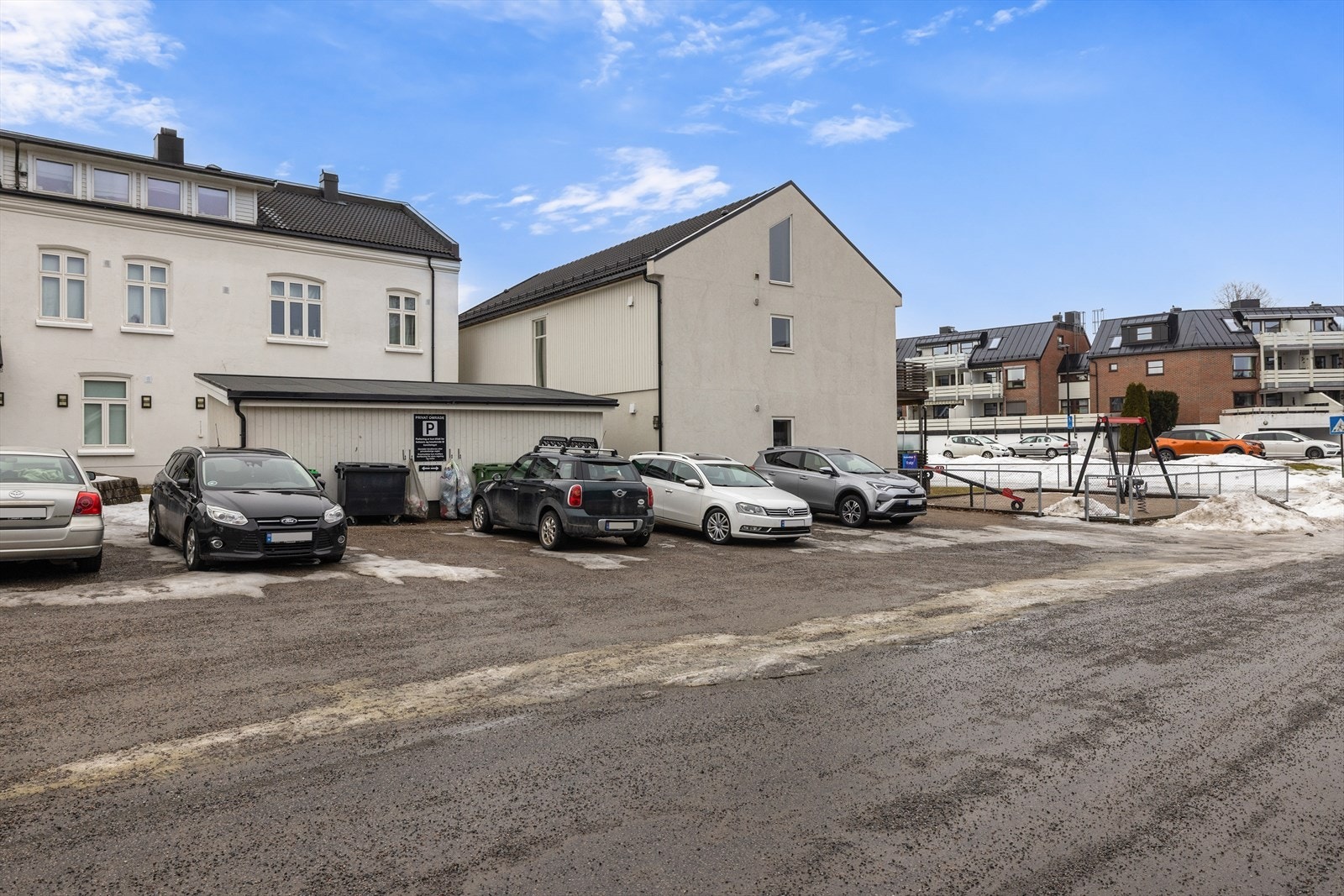 Det er flere biloppstillingsplasser på sørsiden av boligen Galleribilde