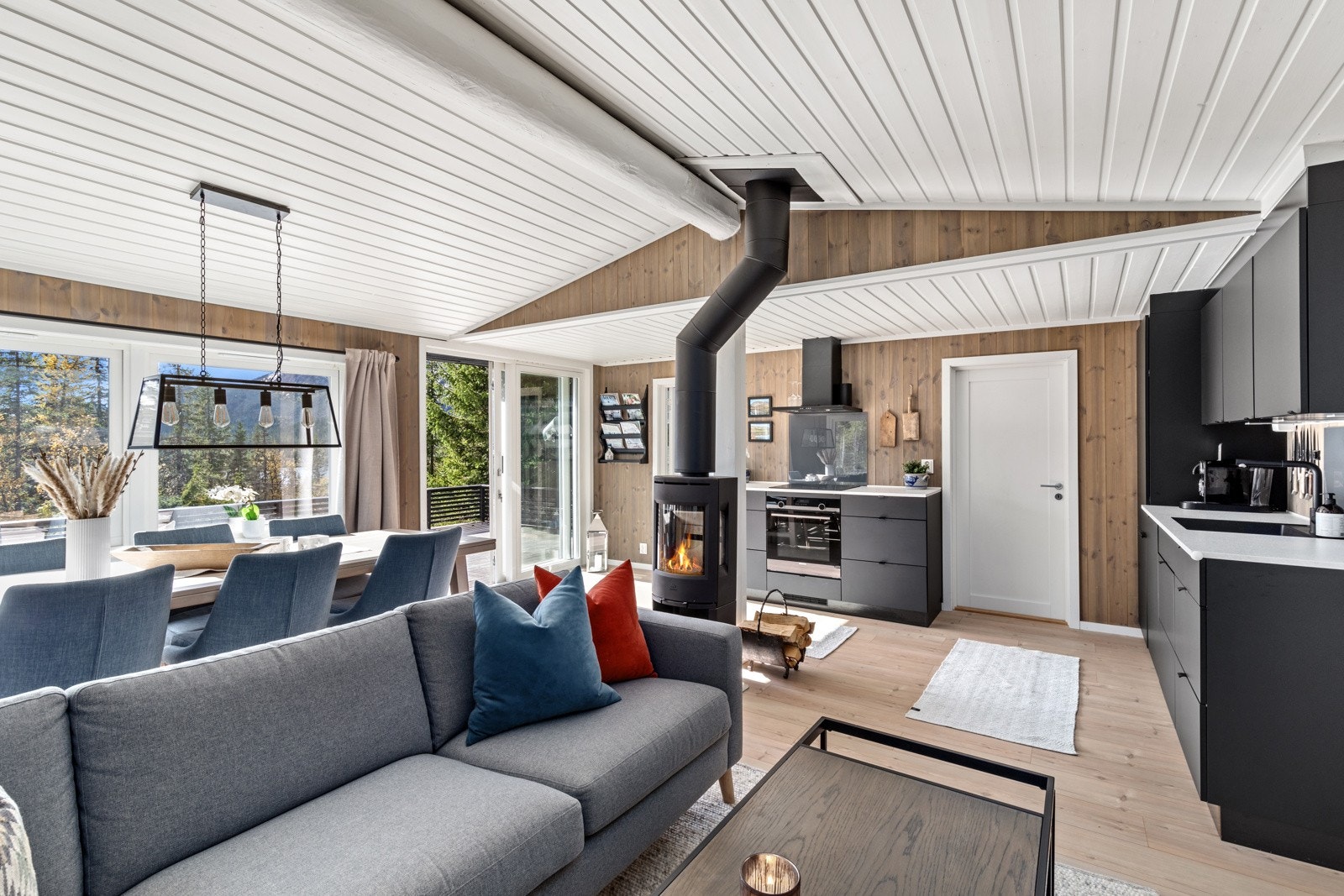 Romslig stue med høytrykkslaminat på gulv og peisovn fra Jøtul Galleribilde