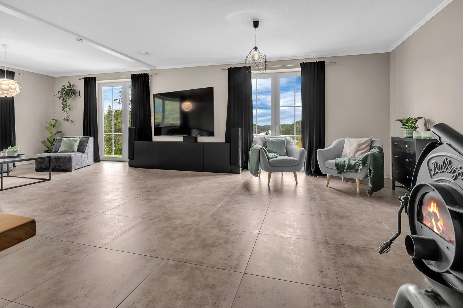 Lys og romslig stue med store vindusflater som gir godt med naturlig lys og utsikt mot uteområdet. Galleribilde