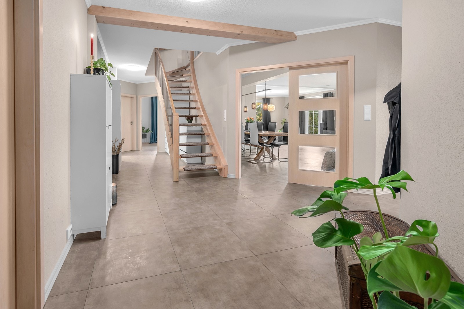 Åpen gang med flislagt gulv og trapp i tre. Galleribilde