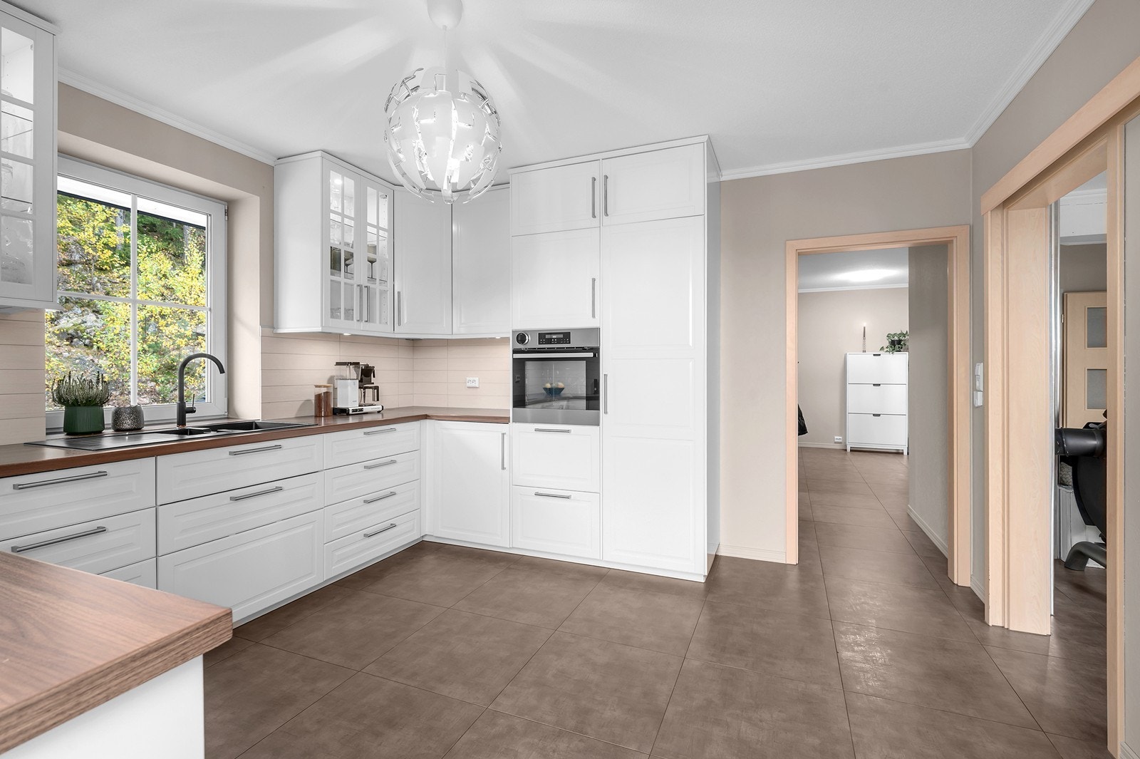 Moderne kjøkkenløsning med oversiktlig planløsning og rikelig med skapplass. Galleribilde