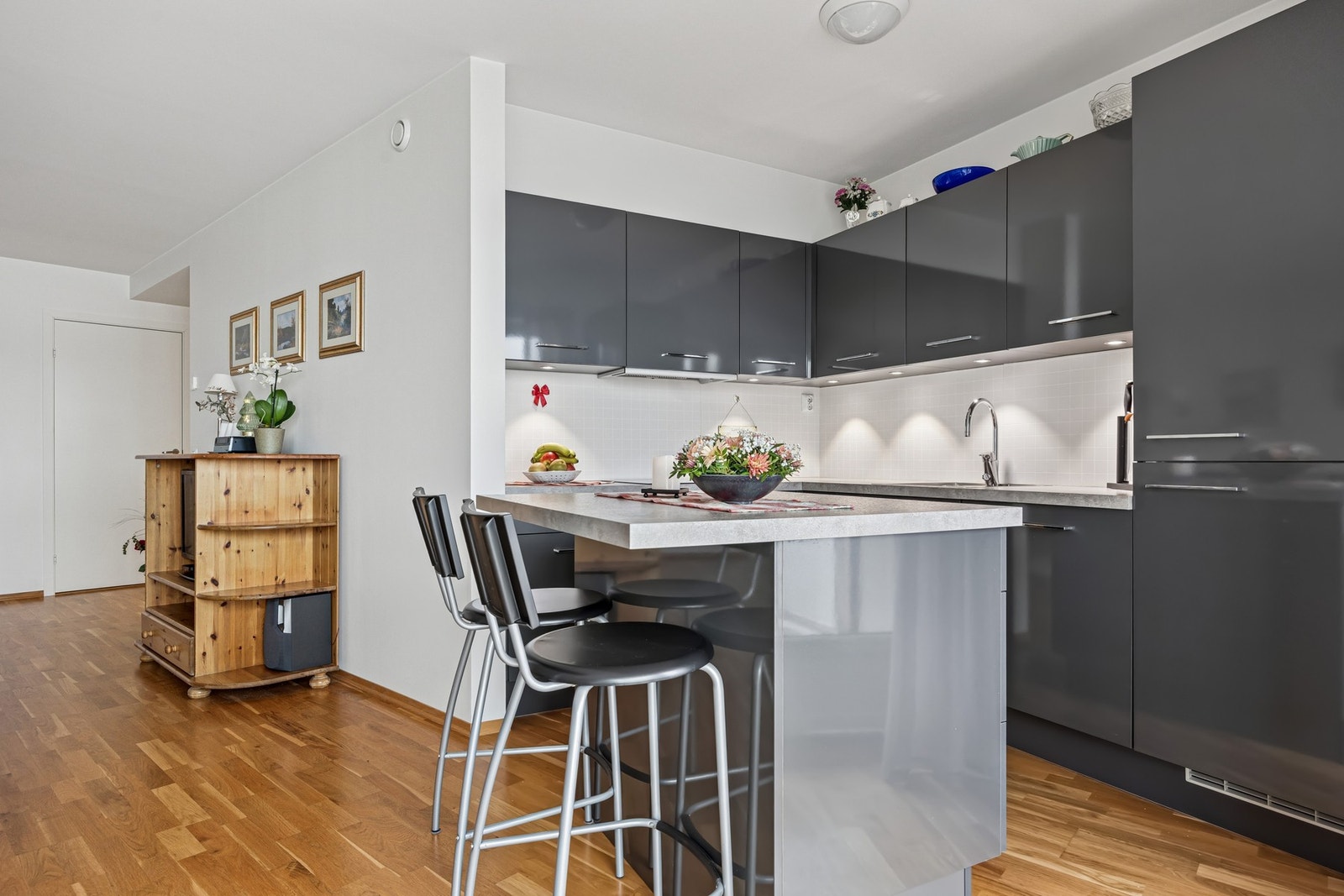 Leiligheten har et moderne og stilrent Mobalpa-kjøkken fra 2013, utformet i en åpen løsning mot stue som skaper en sosial og luftig atmosfære. Galleribilde