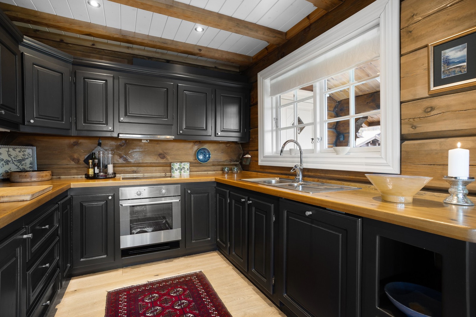 Kjøkkeninnredningen er klassisk med profilerte fronter og benkeplate i heltre Galleribilde