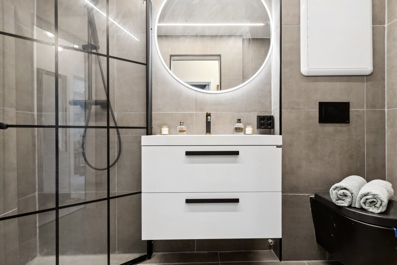 Bad med dusjvegger av glass og dusjgarnityr på vegg. Galleribilde