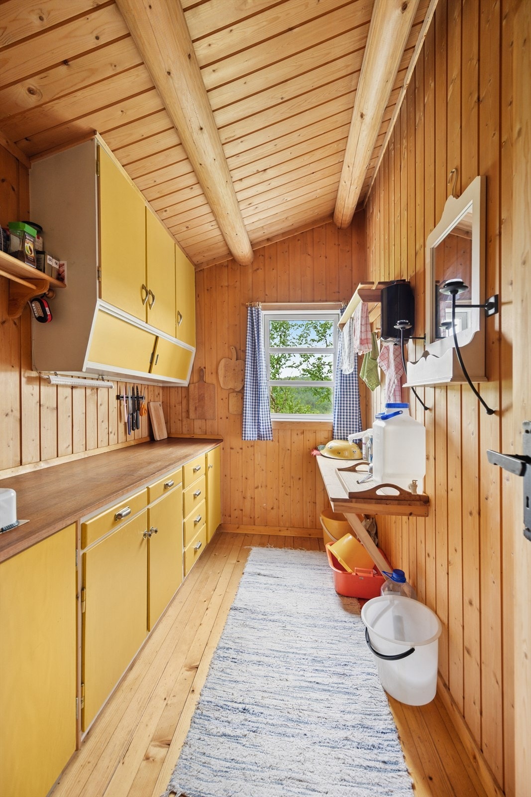 Romslig kjøkken med glatte fronter og benkeplate i tre. Frittstående gasskoketopp. Galleribilde