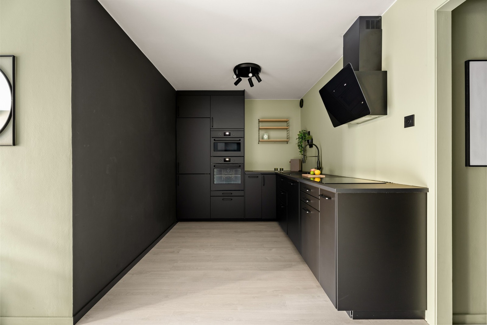 Innredningen har sorte, glatte fronter og koksgrå laminatbenkeplate med nedfelt, sort kum. Galleribilde