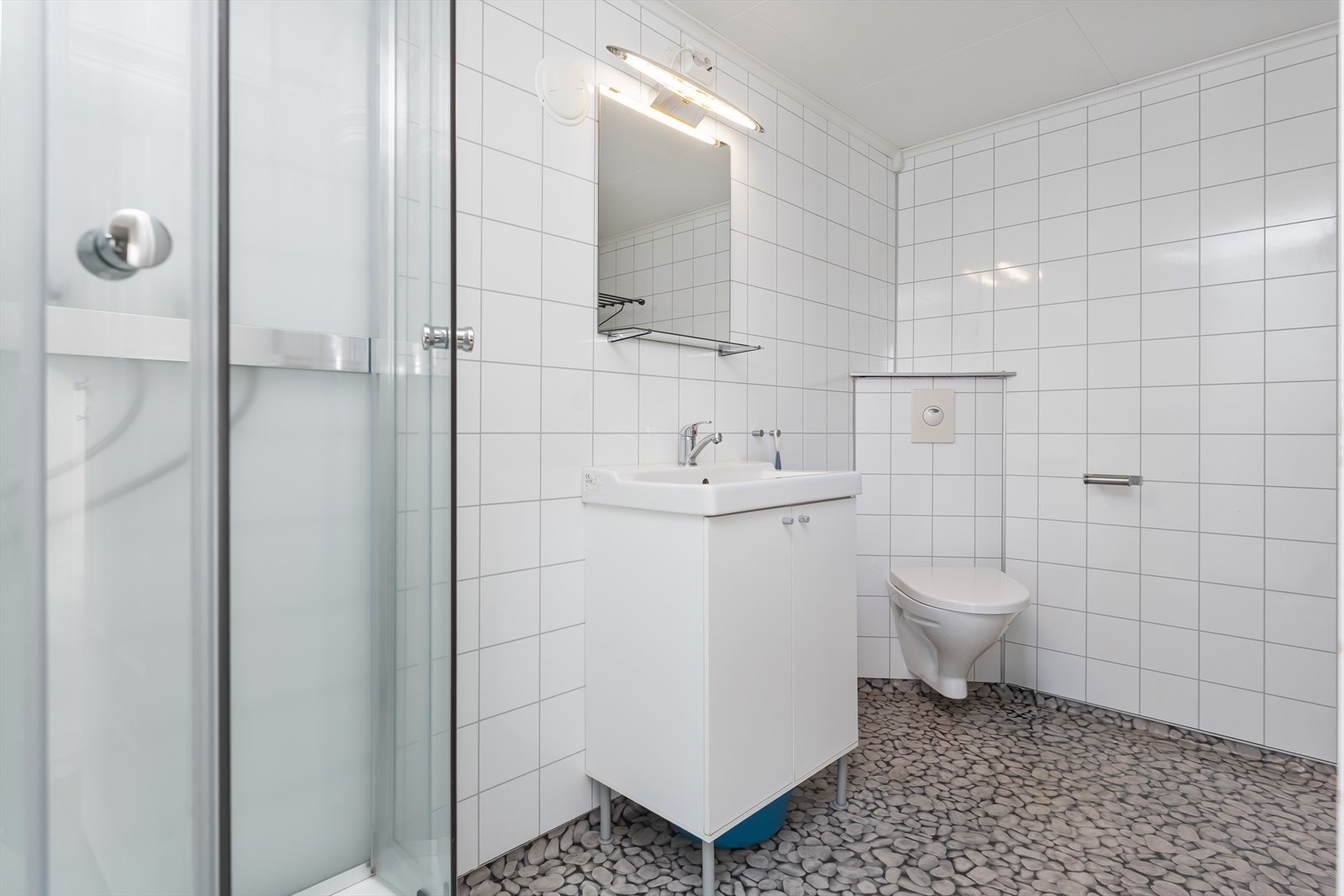 Badet har en dusjkabinett og enkel servant med speil og wc. Galleribilde