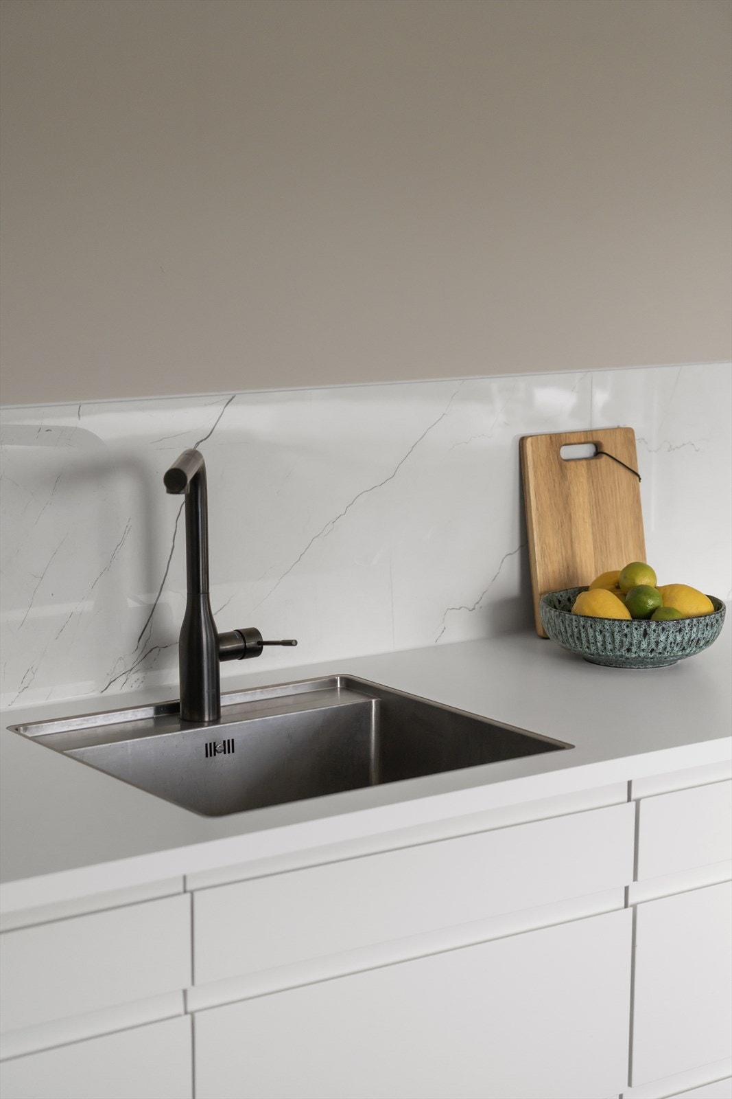 Stilrent kjøkkeninnredning med praktisk vask og moderne armatur. Galleribilde