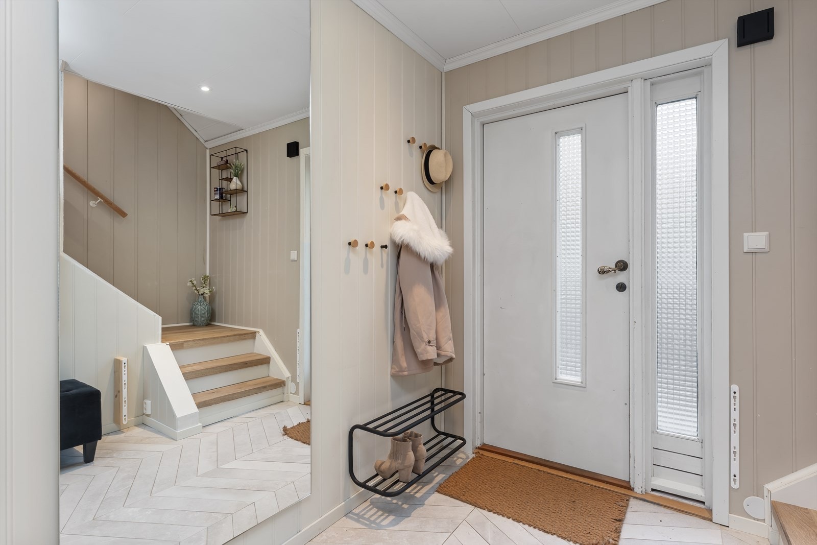 Entréen har flislagt gulv med mønster og god plass til oppbevaring av yttertøy. Galleribilde
