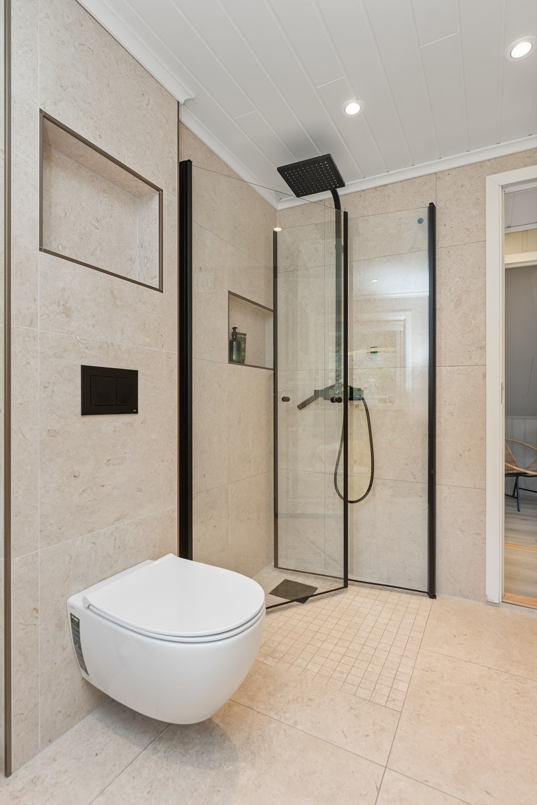 Dusjen har en elegant glassvegg og regndusj med svarte detaljer. Galleribilde