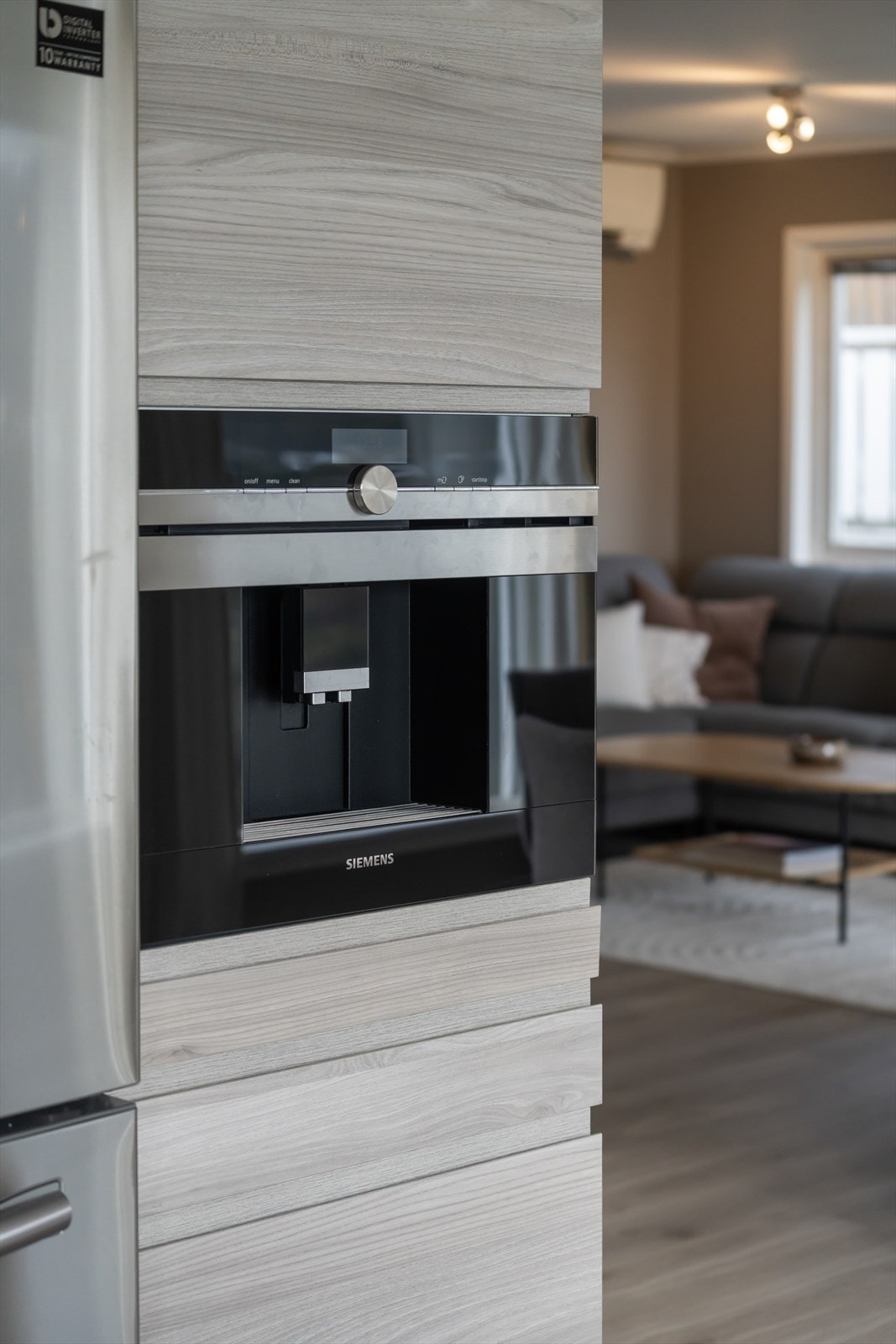 Kjøkkenet er utstyrt med integrerte hvitevarer, inkludert en moderne kaffemaskin, som gir en stilfull og funksjonell arbeidsplass. Galleribilde