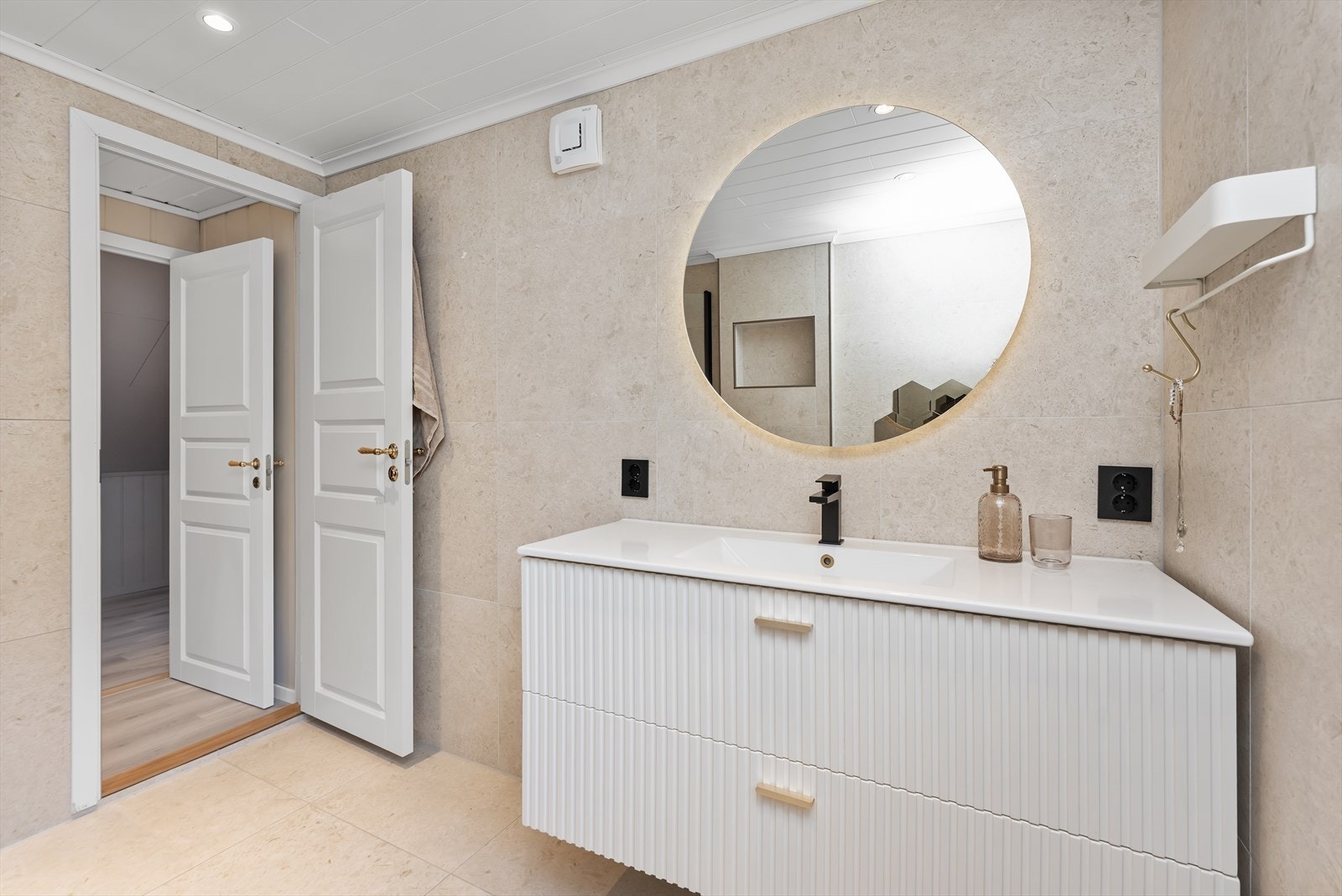 Badet er utstyrt med en stilfull servant med profilerte fronter, dusjhjørne og vegghengt wc. Galleribilde