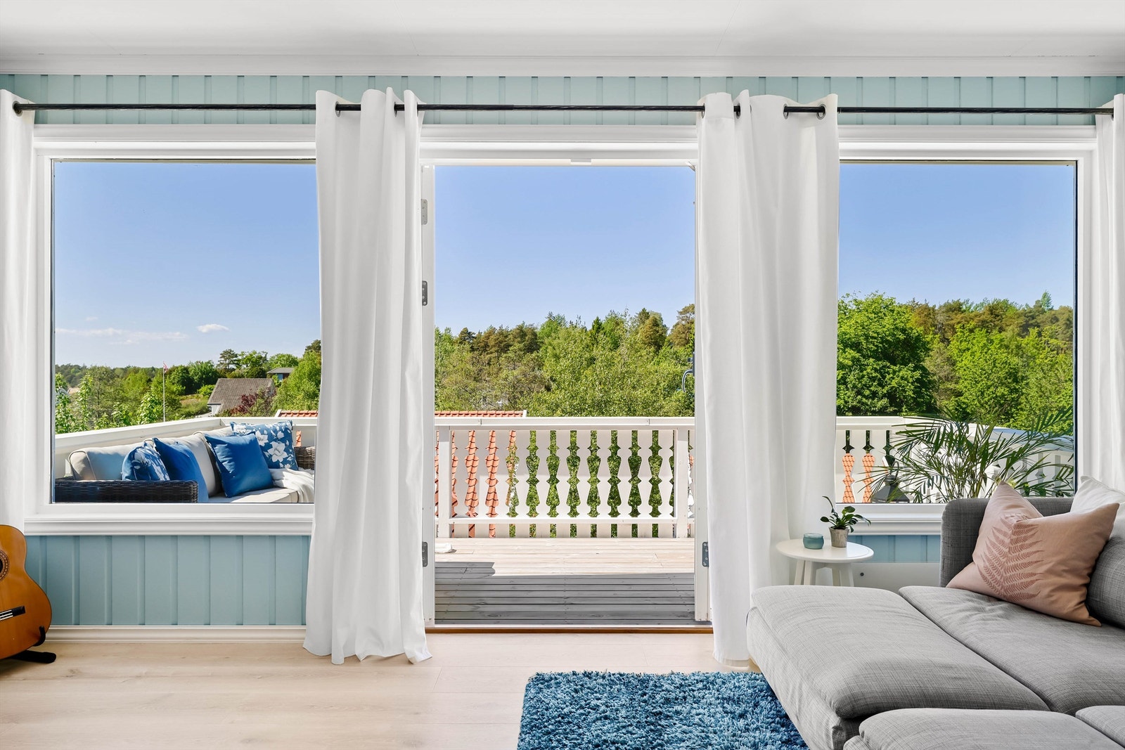 Vindusrekke mot vest fyller stuen i andre etasje med dagslys og ettermiddags-/kveldssol. Galleribilde