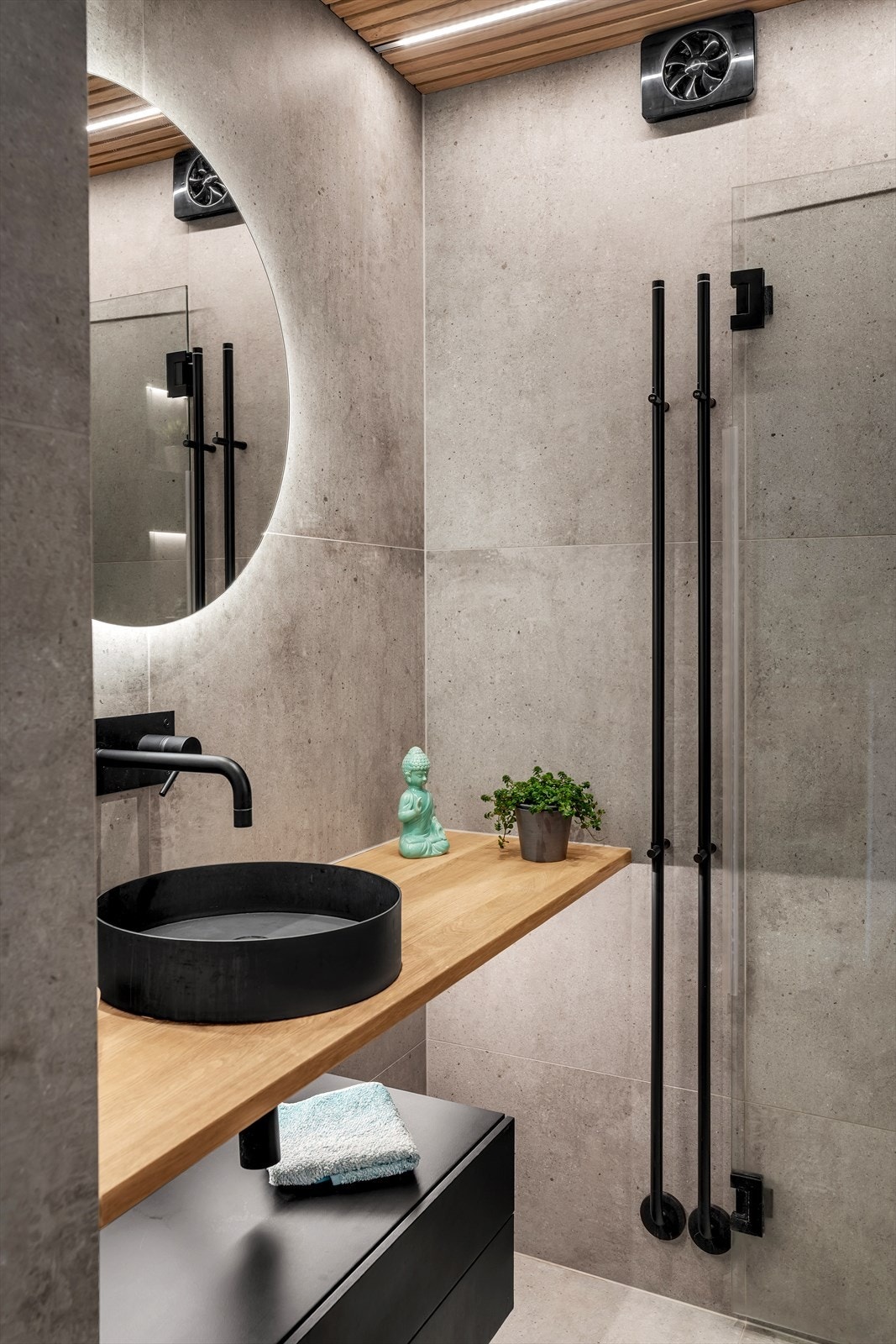 Moderne innredet med vegghengt servant med benkeplate av tre og ovenpåliggende, rund vask. Galleribilde