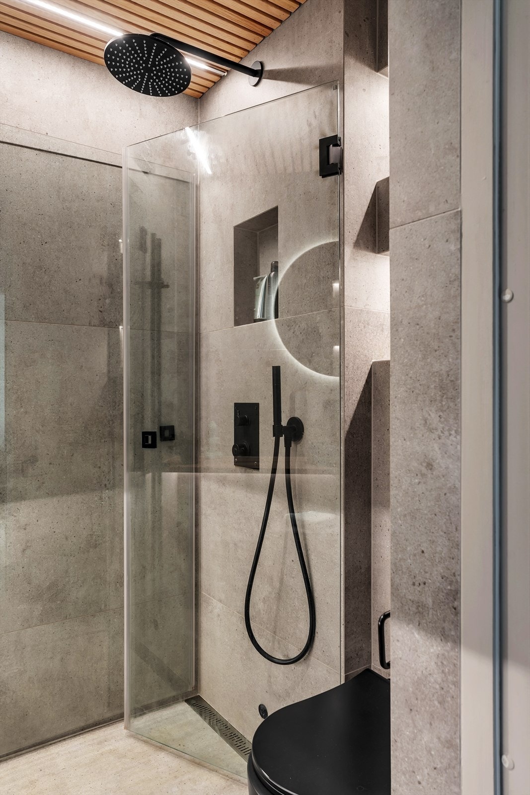 Vegghengt toalett og dusjhjørne med innfellbare dusjdører av glass. Galleribilde