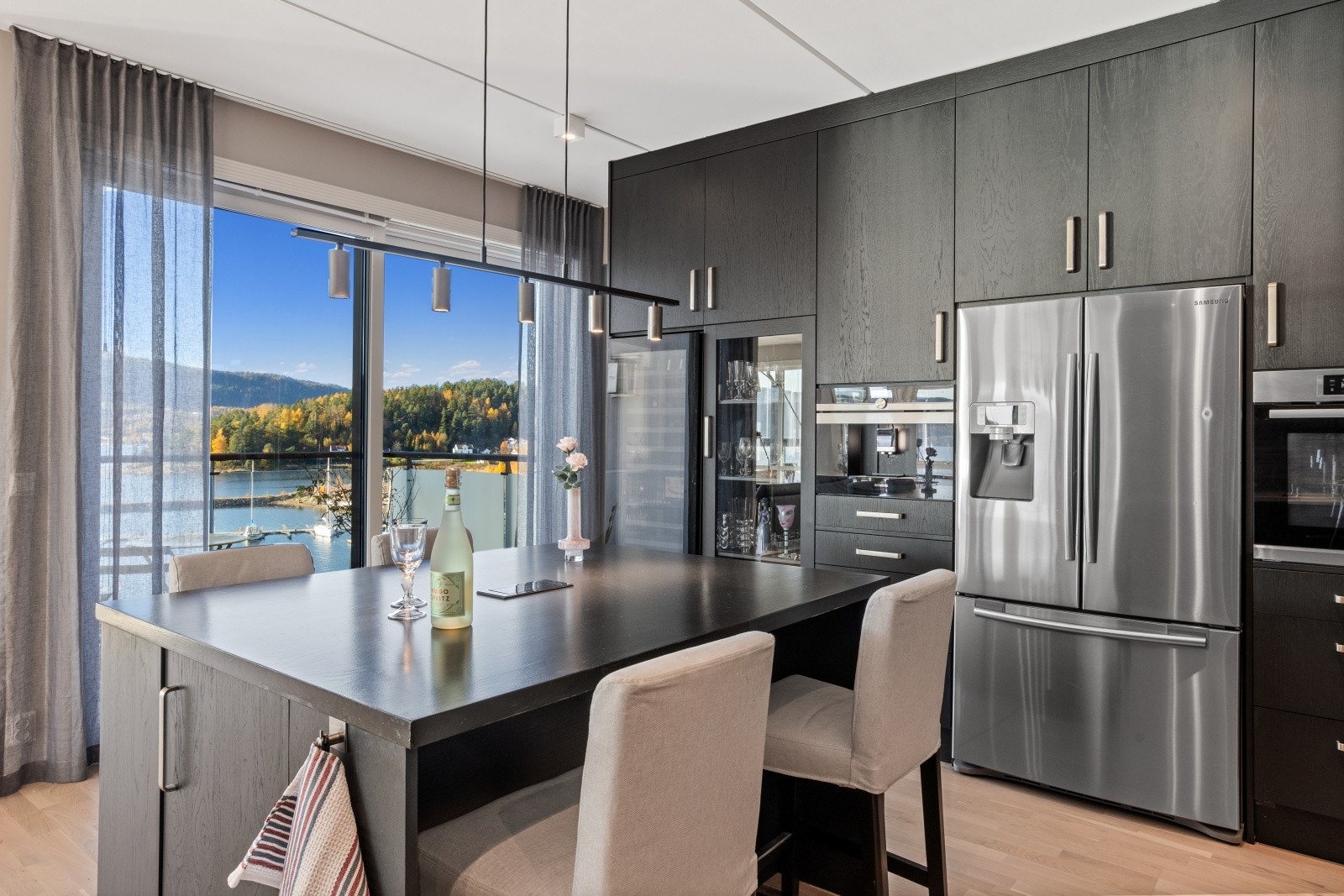 Sosialt utformet kjøkken med fantastisk utsikt fra kjøkkenøy med fire sitteplasser. Utgang til solrik og hyggelig balkong med fin sjøutsikt. Galleribilde