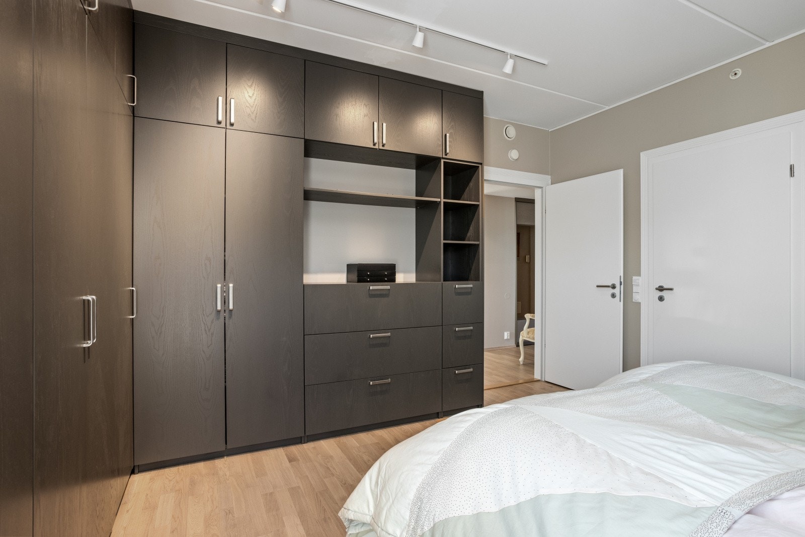 Her ser vi hovedsoverommet med plass til dobbeltseng og nattbord. Stort spesialtilpasset garderobeskap montert i 2020. Spottskinne. Direkte adkomst til badet. Galleribilde