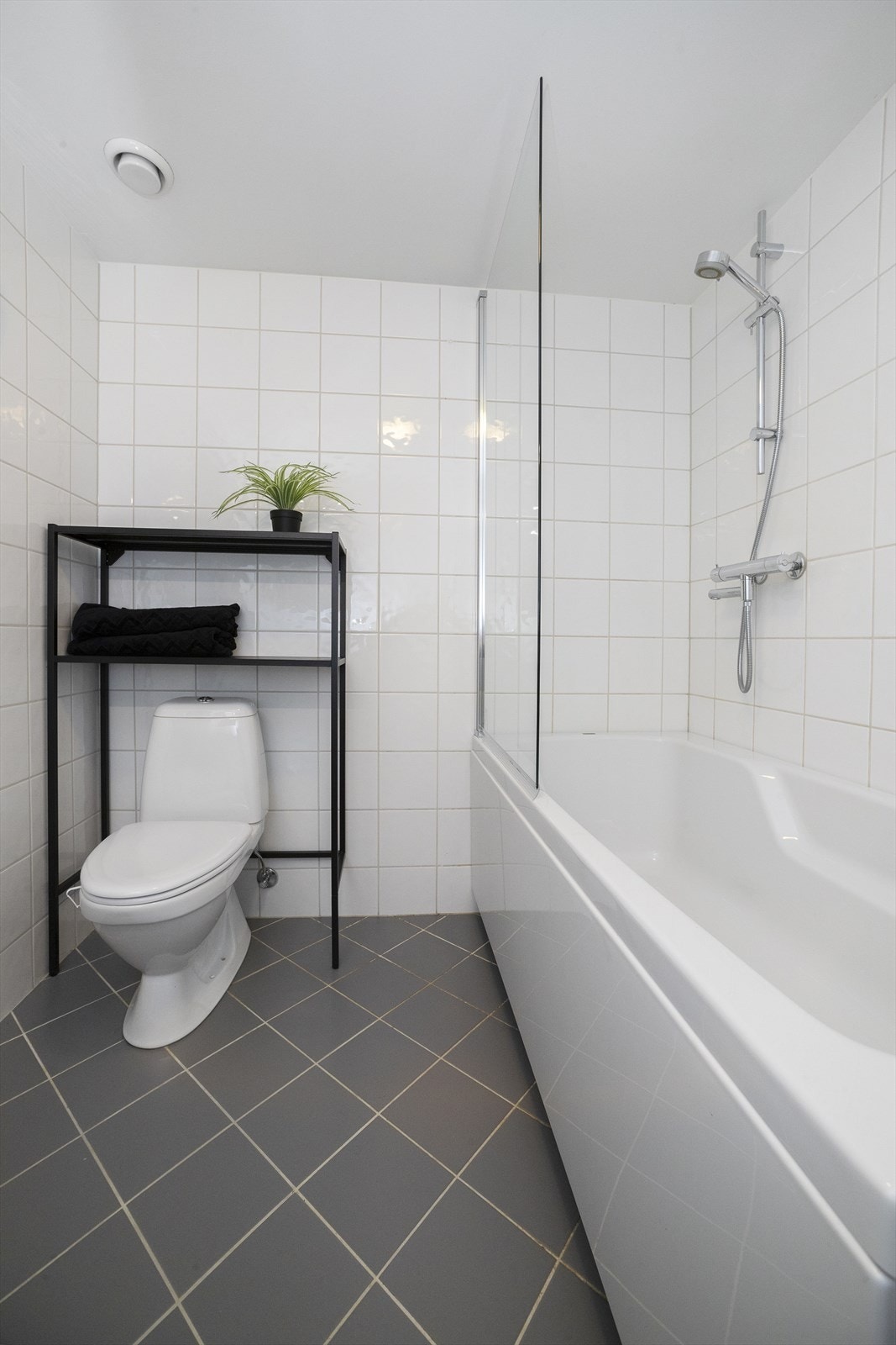 Badet har gulvstående toalett og opplegg for vaskemaskin Galleribilde