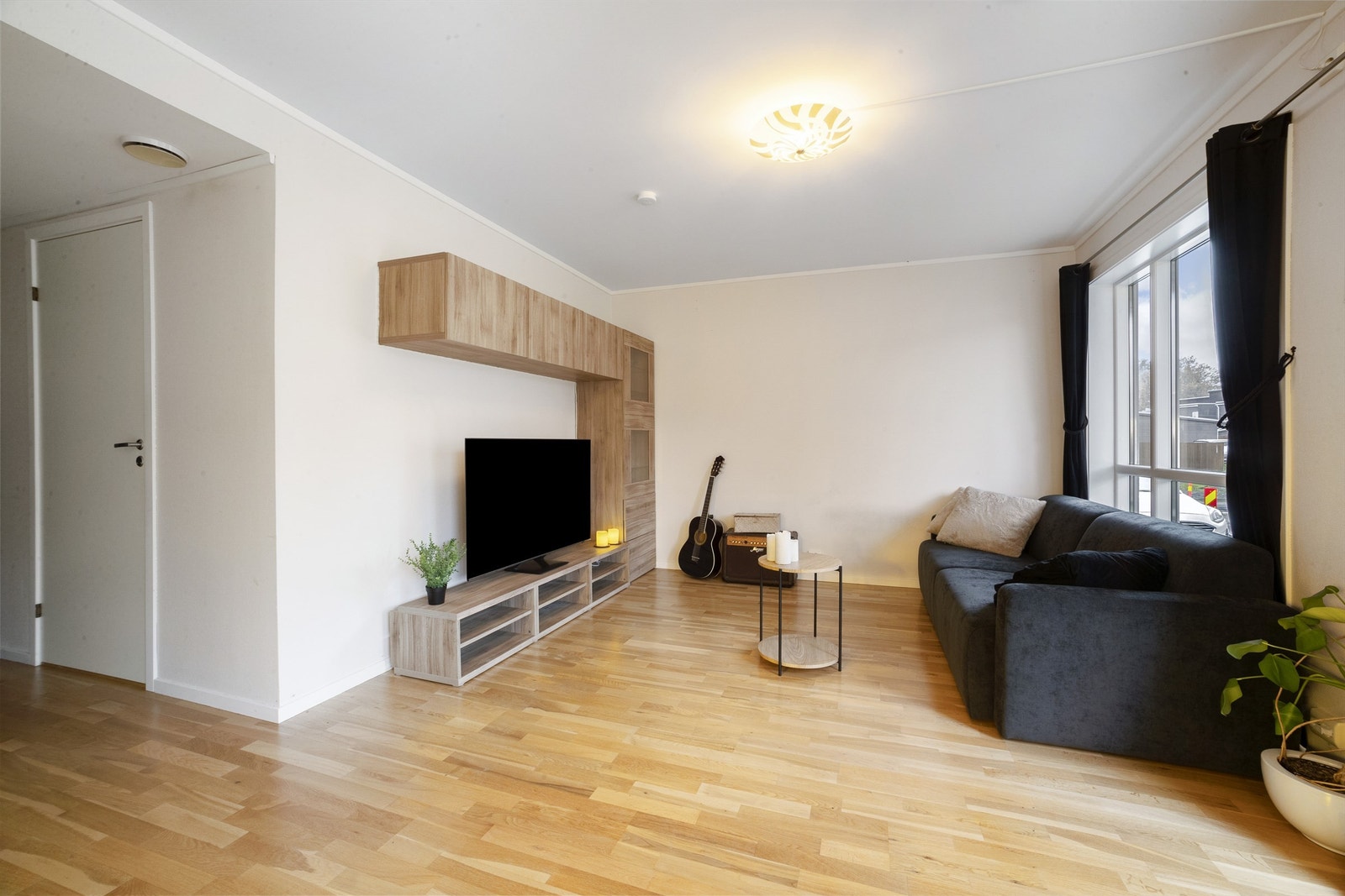 Stuen har god plass til sofa, sofabord og TV, samt at det er montert en plassbygd seksjon for TV'en Galleribilde