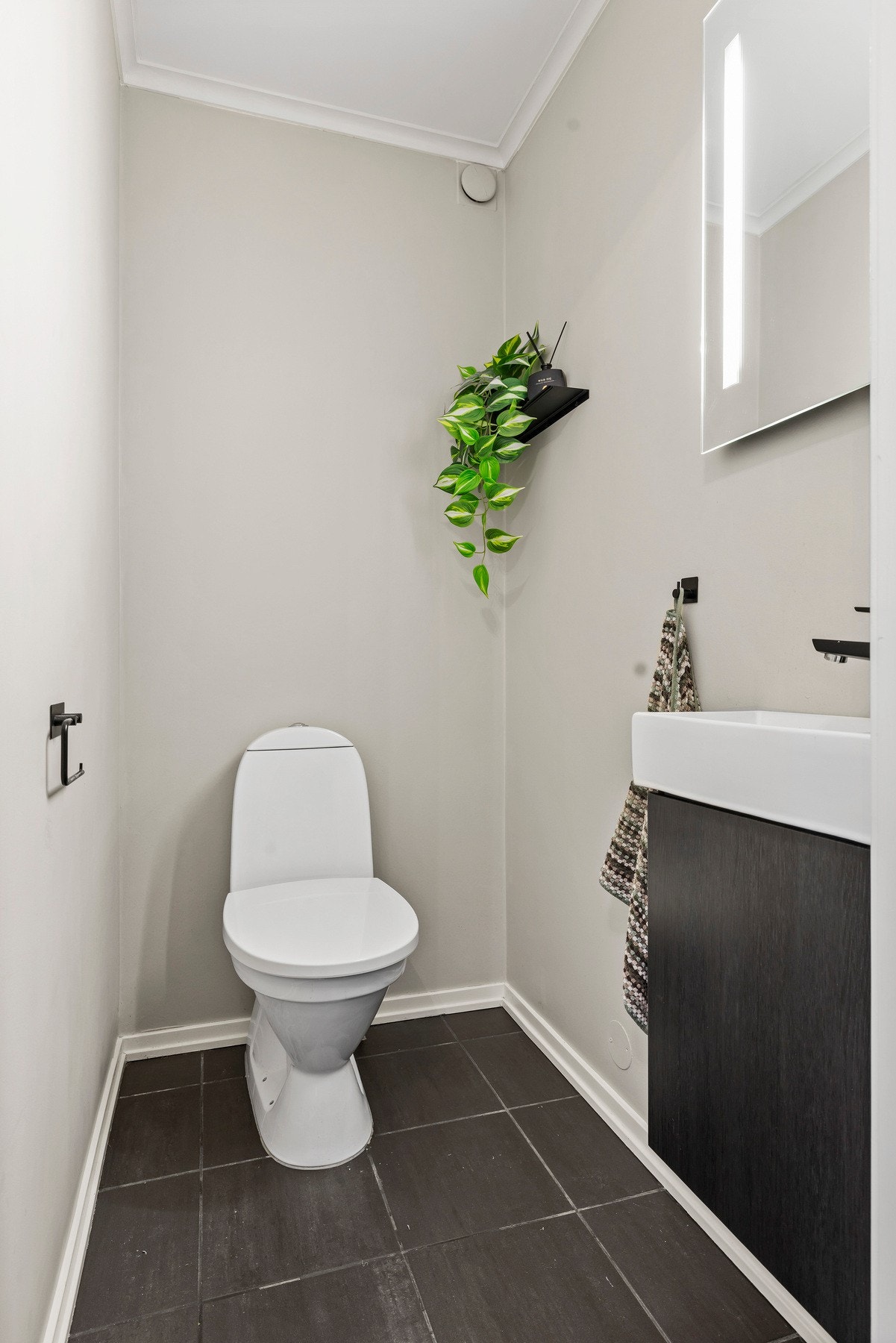 Toalettrommet er utstyrt med et gulvstående toalett og en enkel innredning med slette fronter Galleribilde