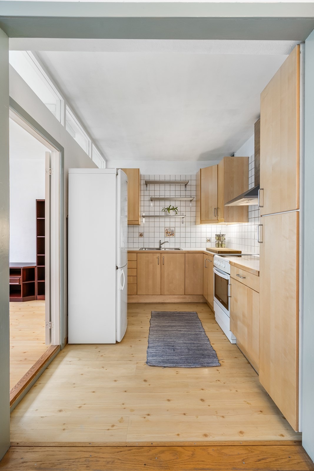 Kjøkkenet har innredning med glatte fronter. Benkeplaten er av laminat, og kjøkkenventilator med kullfilter Galleribilde