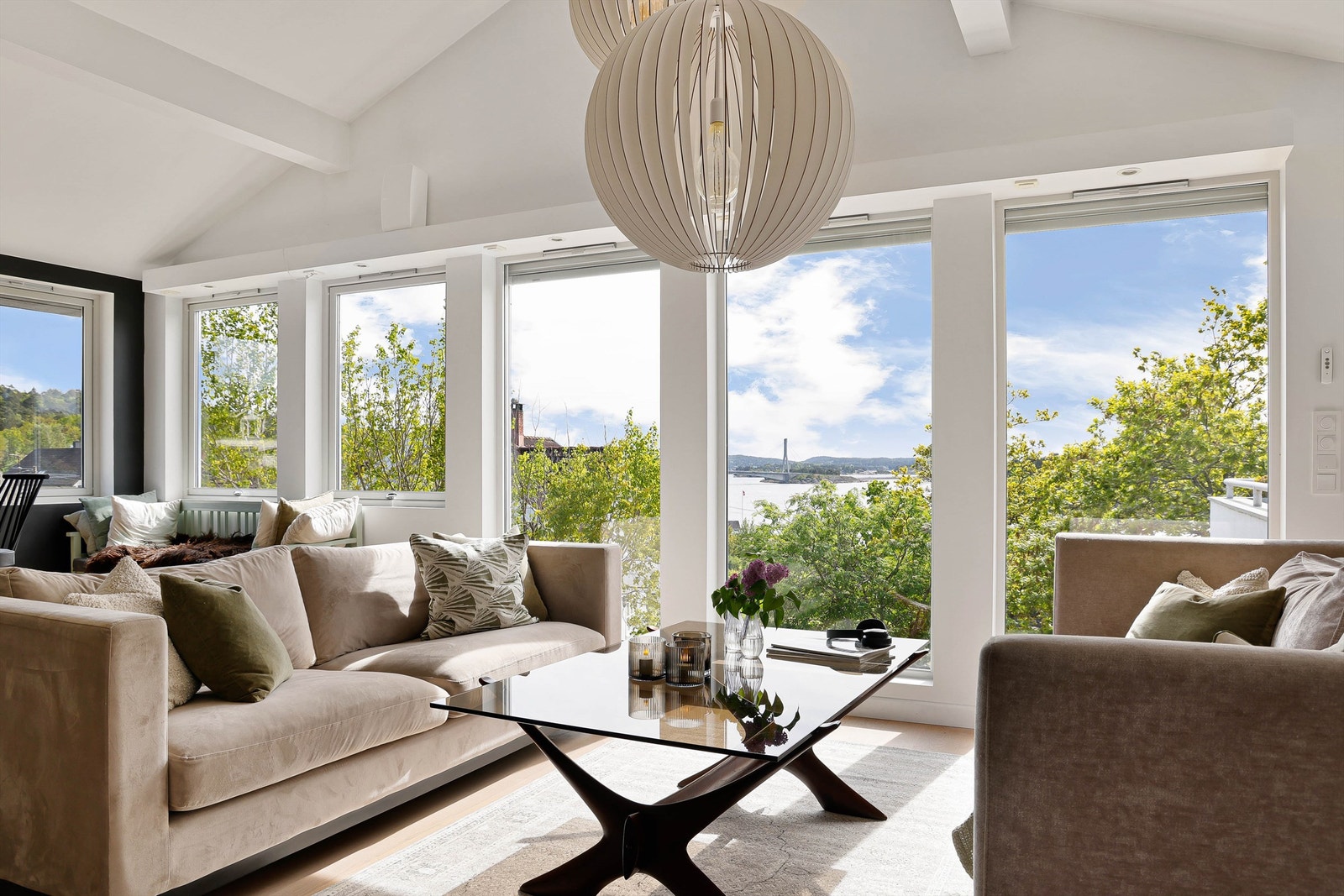 Rekken av vertikalstilte vinduer fyller stuen med solstråler og mye naturlig lys dagen gjennom. Galleribilde