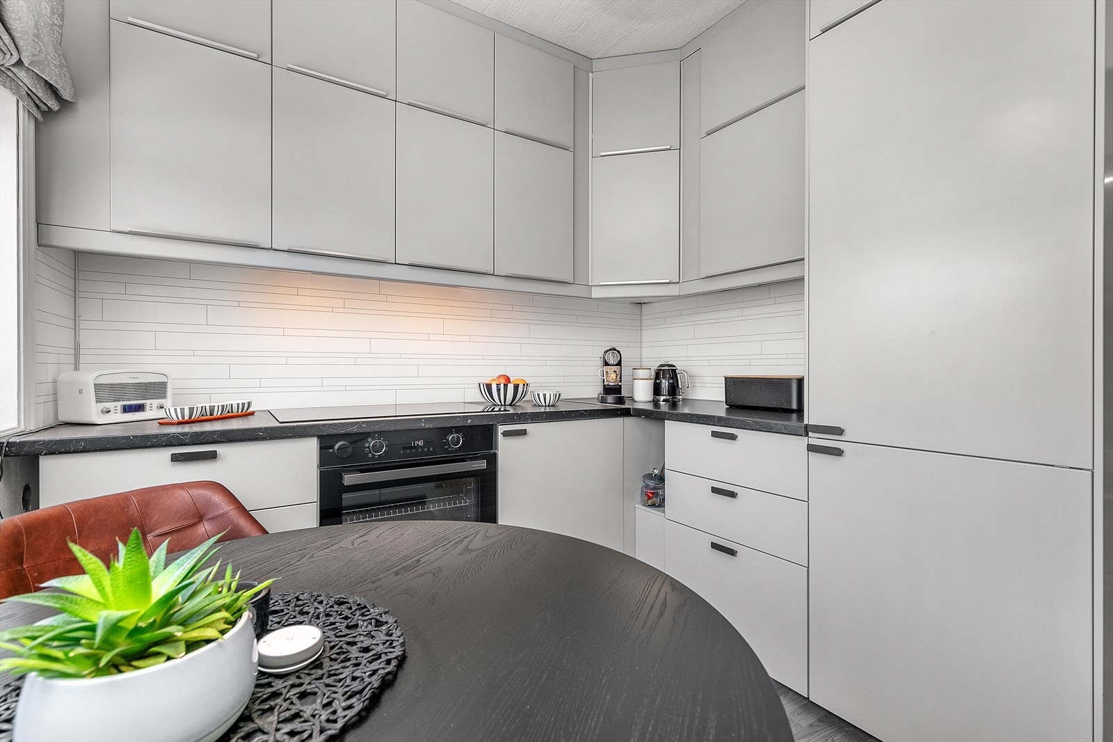 Kjøkkenet er utstyrt med kjøl/fryseskap, oppvaskmaskin, induksjonstopp og stekeovn, og kjøkkenventilator med avtrekk ut. Galleribilde