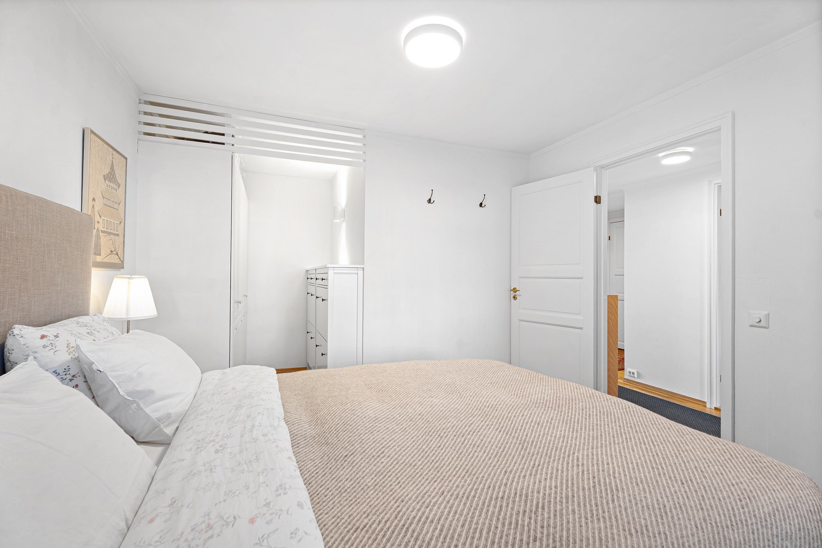 Stort hovedsoverom med rolige fargetoner og god lagringsplass Galleribilde