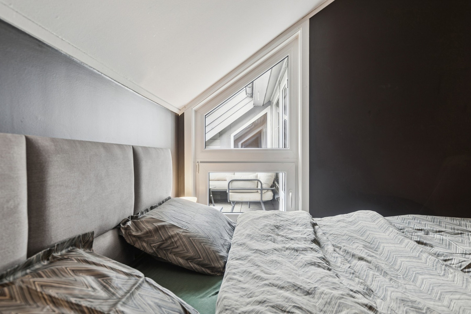 Leiligheten har et lunt og innbydende soverom med skråtak og moderne fargevalg. Galleribilde