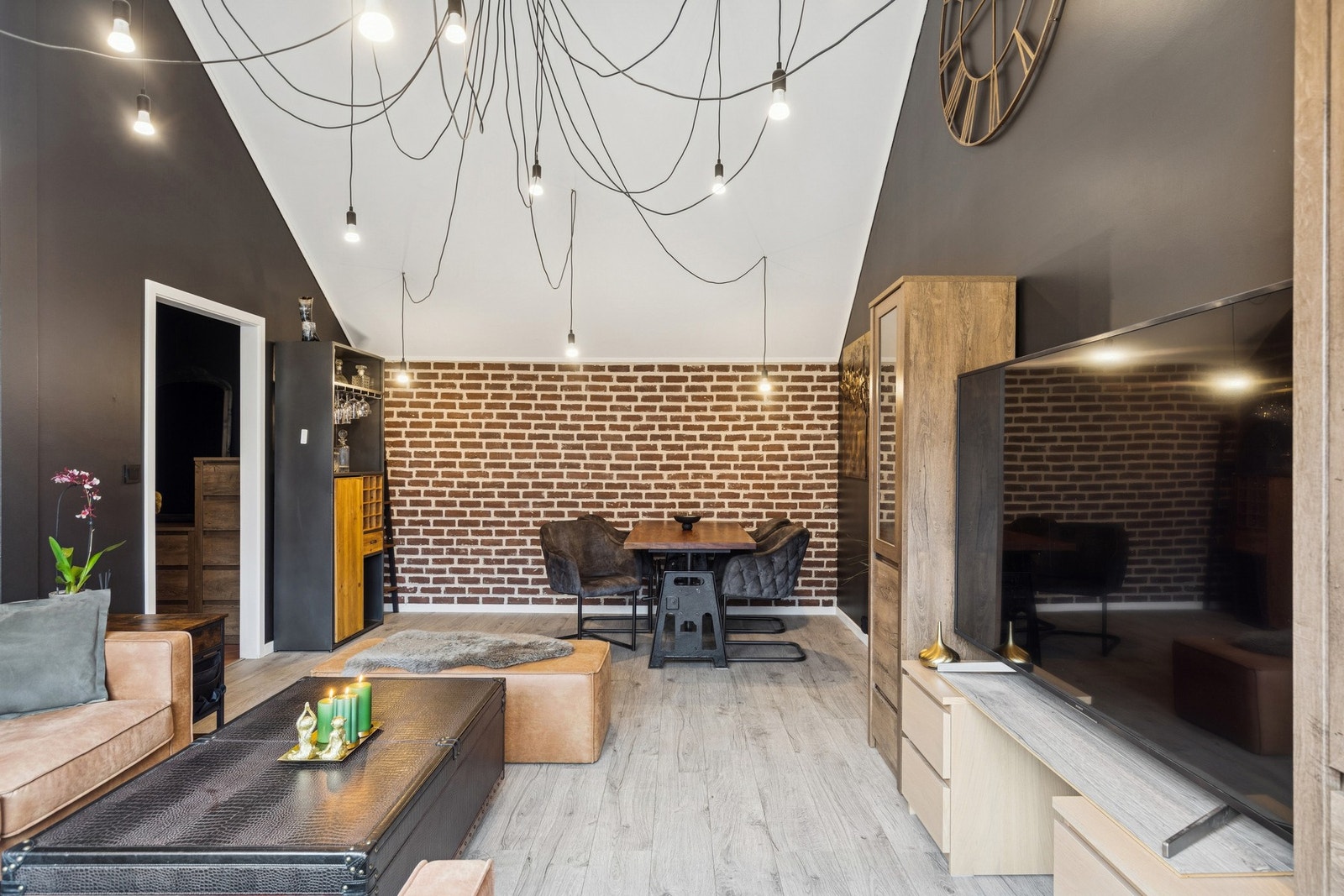 Her oppleves rommet luftig og lyst, samtidig som de mørke veggene og teglsteinsdetaljene skaper en lun og moderne atmosfære. Galleribilde