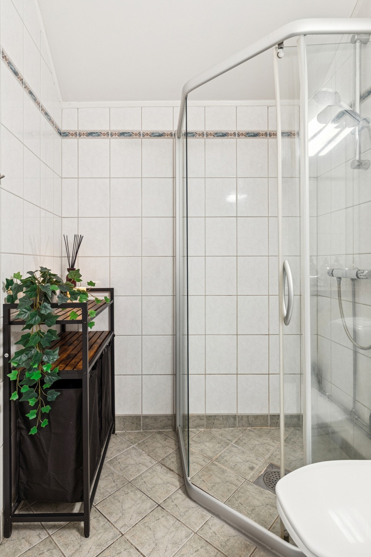 Rommet er innredet med dusjhjørne med glassdører, servantinnredning med speil og belysning, toalett og opplegg for vaskemaskin. Galleribilde