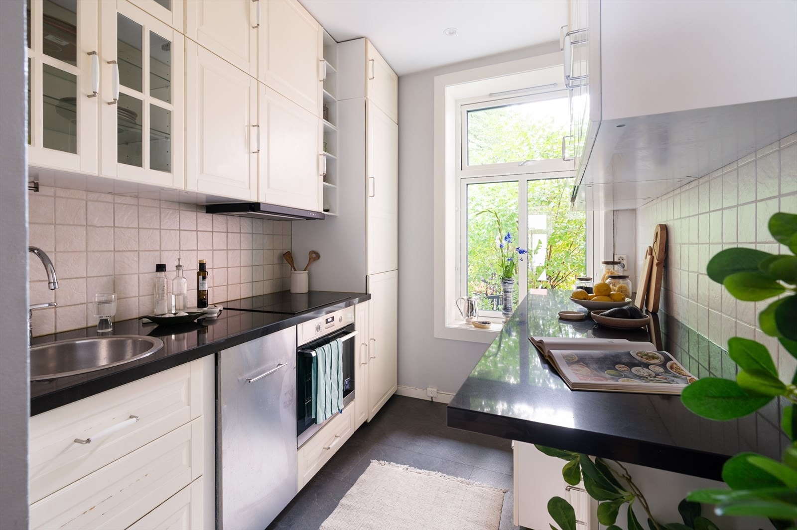 Innredningen har profilerte fronter og benkeplate i stein med nedfelt vaskekum. Overskapene gir godt med oppbevaringsplass, hvor deler av skapene har glassfronter som tilfører et klassisk preg. Galleribilde
