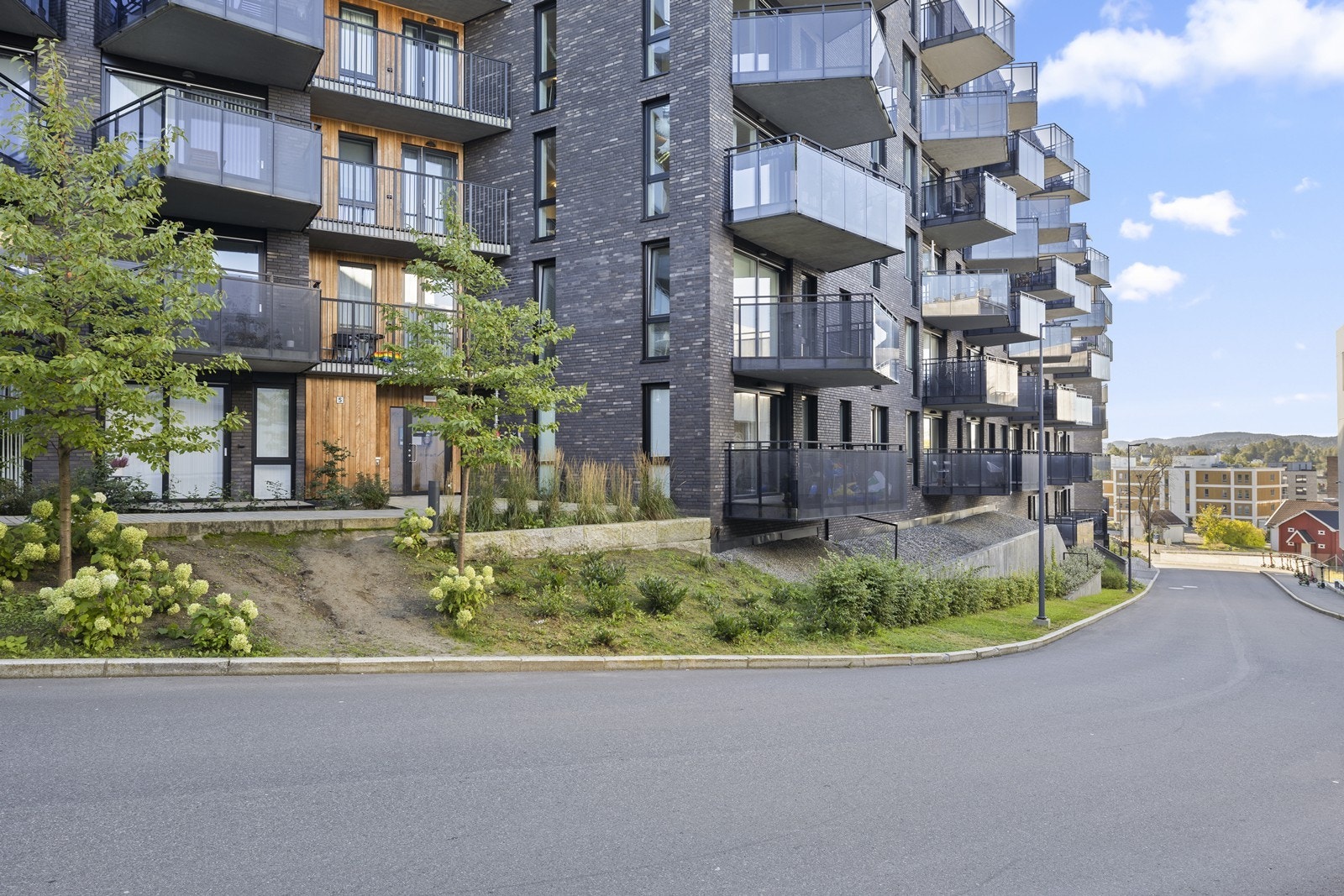 Pent opparbeidede uteområder med beplantning og asfalterte internveier. Galleribilde