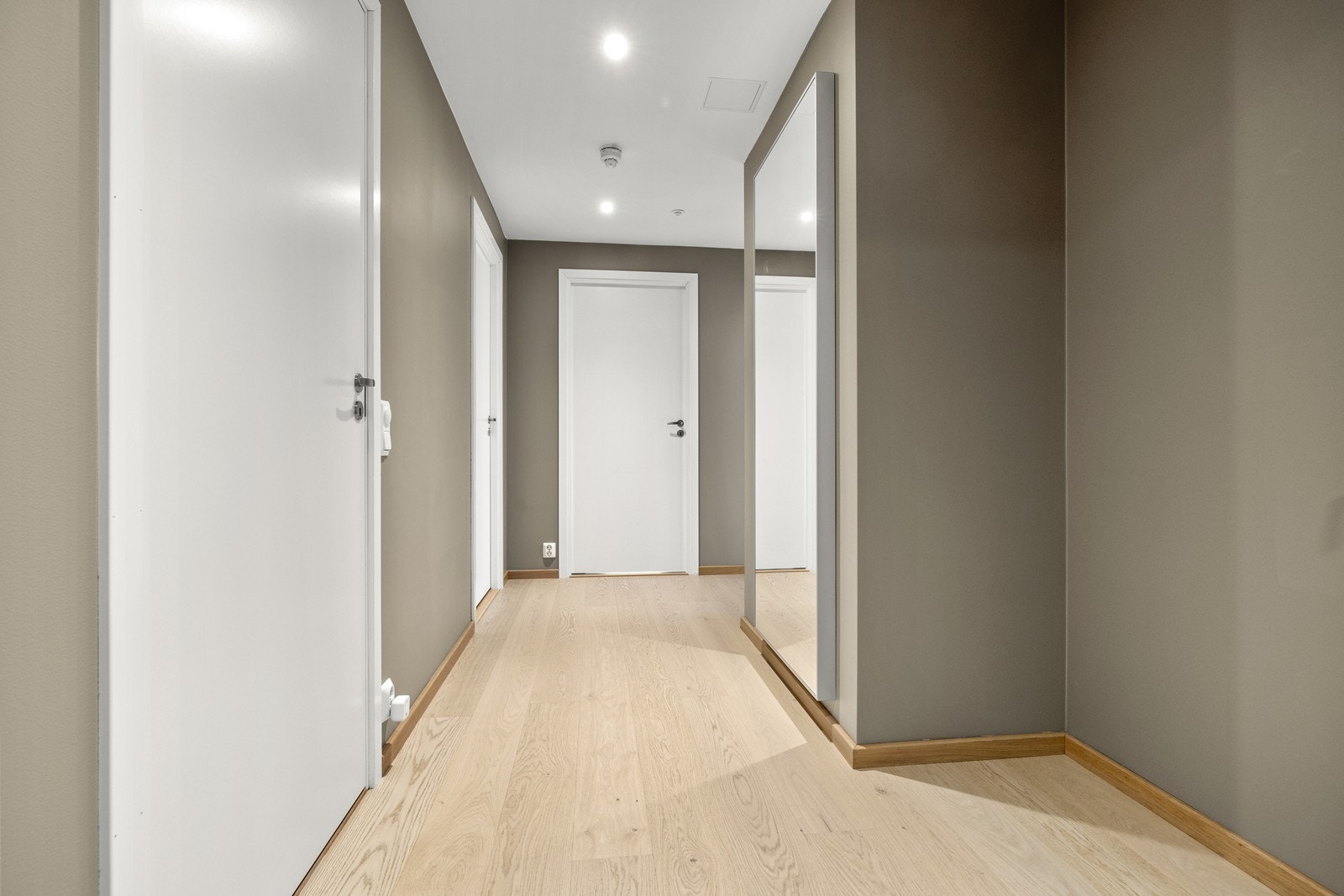 Lys entré med malte overflater og parkett på gulv. Mulighet for oppheng av yttertøy og plassering av sko.Downlights i tak. Galleribilde