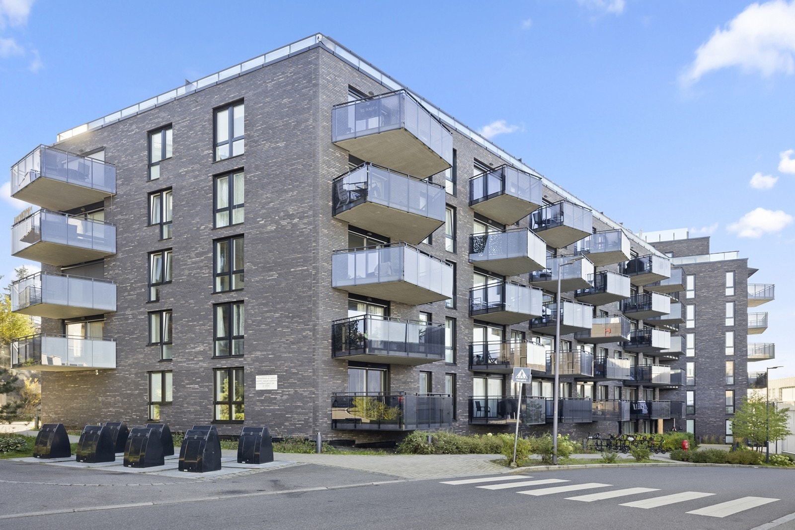 Bygget er fra 2021 og har en moderne fasade forblendet med teglstein. Galleribilde