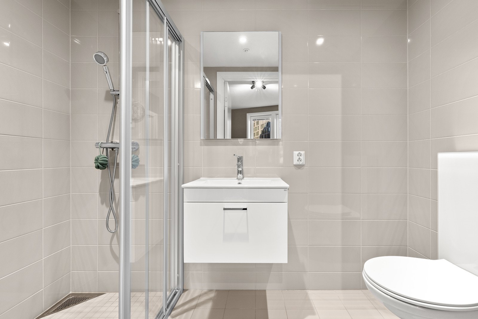 Fra hovedsoverommet er det adkomst til et delikat, flislagt bad med gulvvarme, vegghengt toalett, servant med skuffer og dusjnisje med kabinettdør. Galleribilde