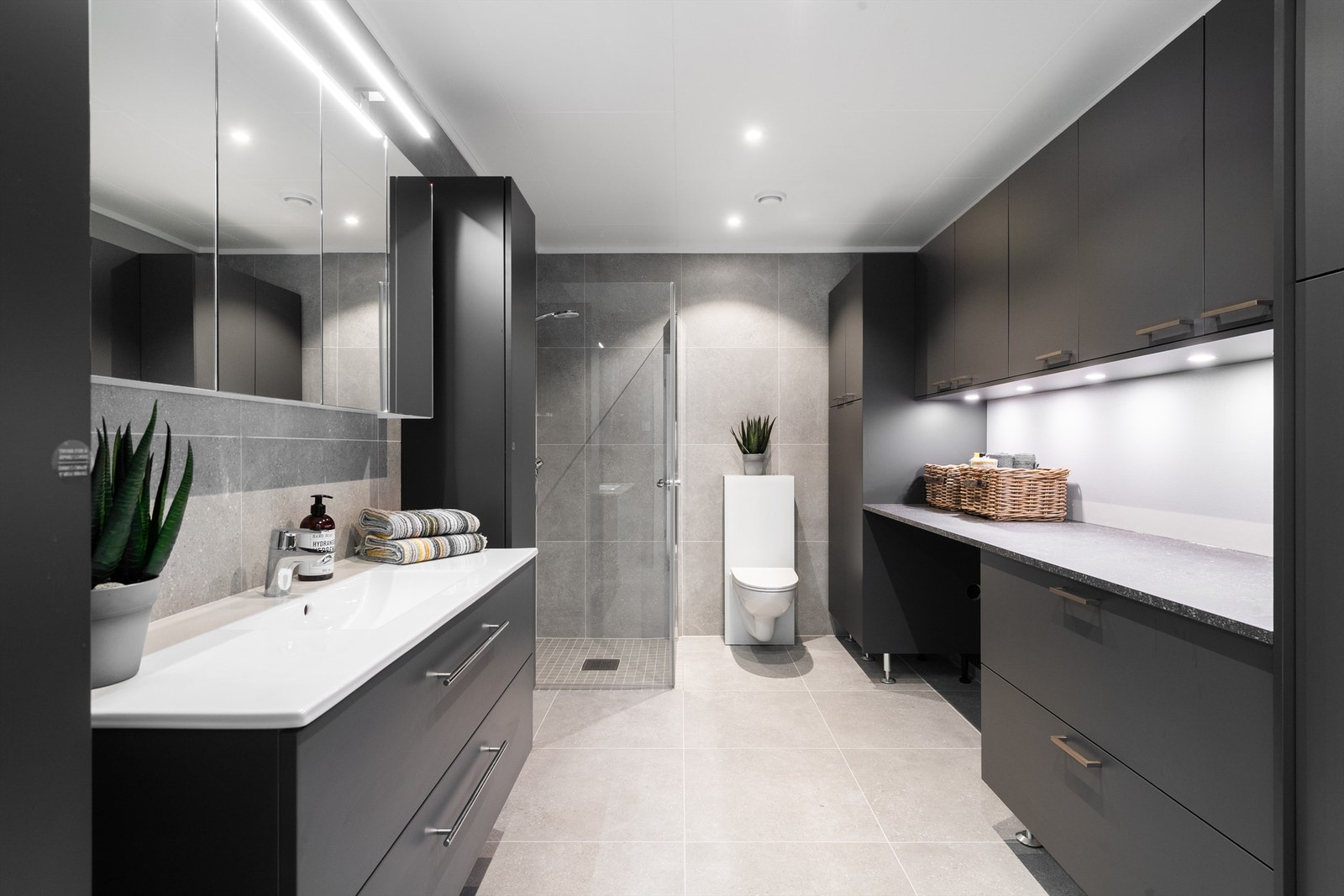 Kombinert bad og vaskerom med gode oppbevaringsmuligheter Galleribilde