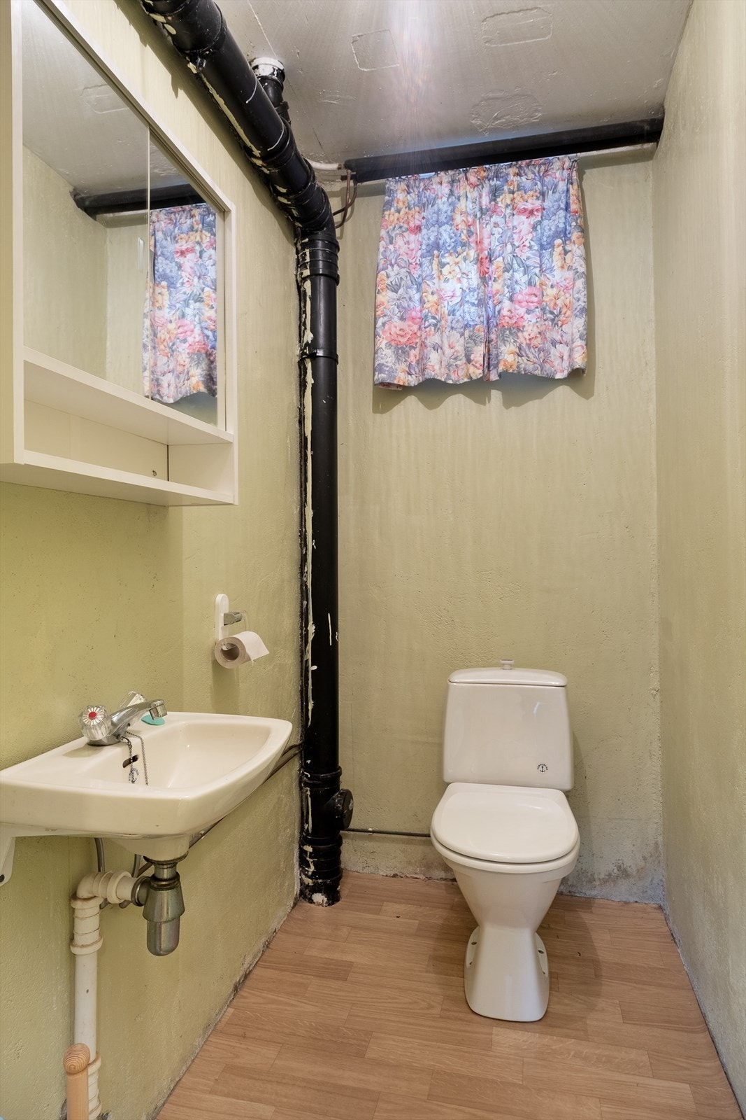 Toalettrom i underetasjen med belegg på golv og måla murveggar. Galleribilde