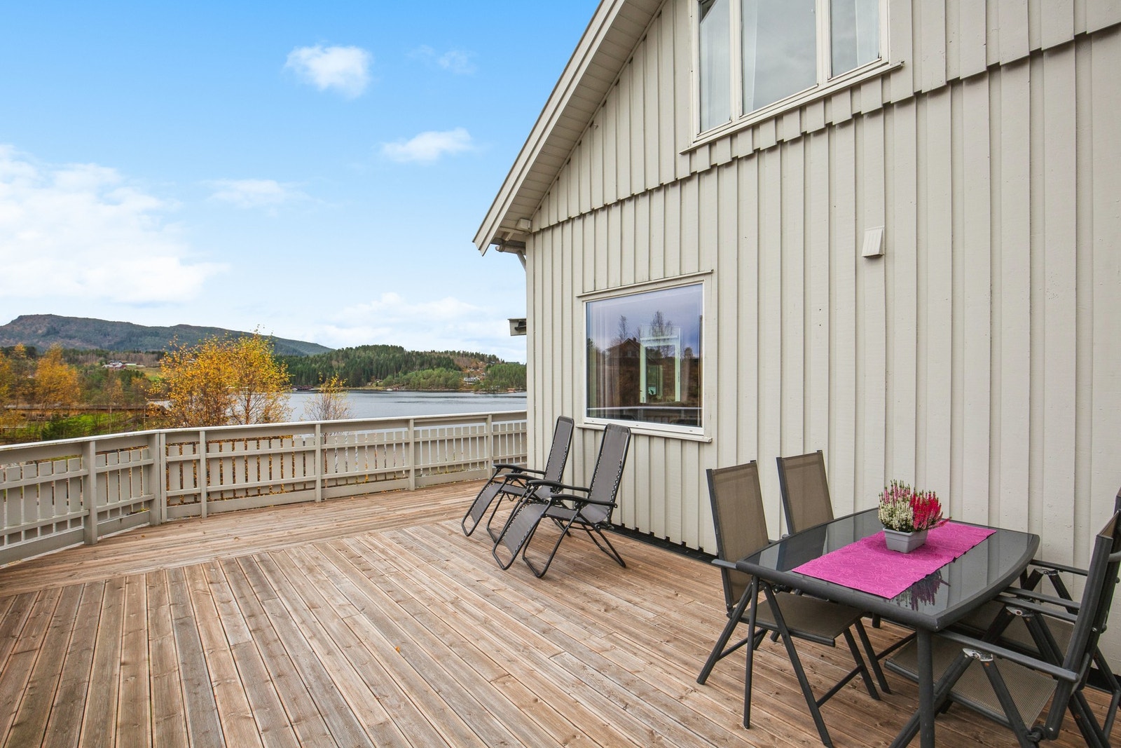 Stor terrasse som strekker seg rundt huset Galleribilde