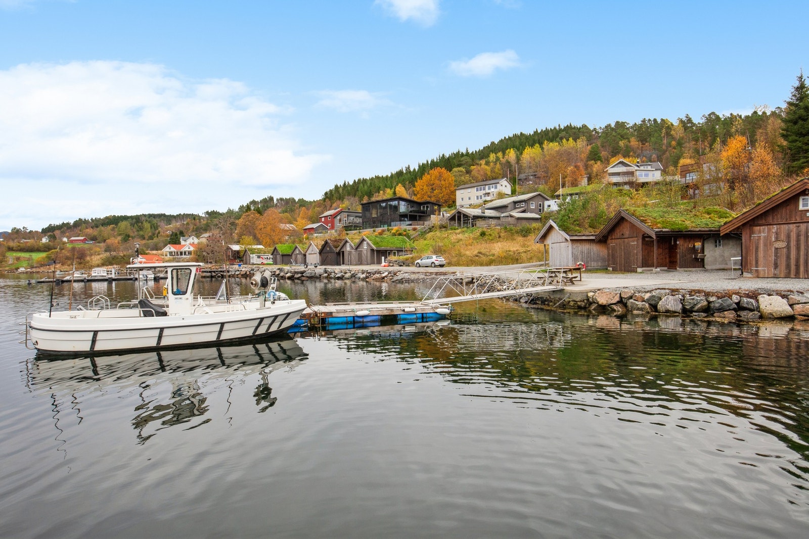 Bilde fra kaia, hvor det er naust og båtplass i flytebrygge Galleribilde