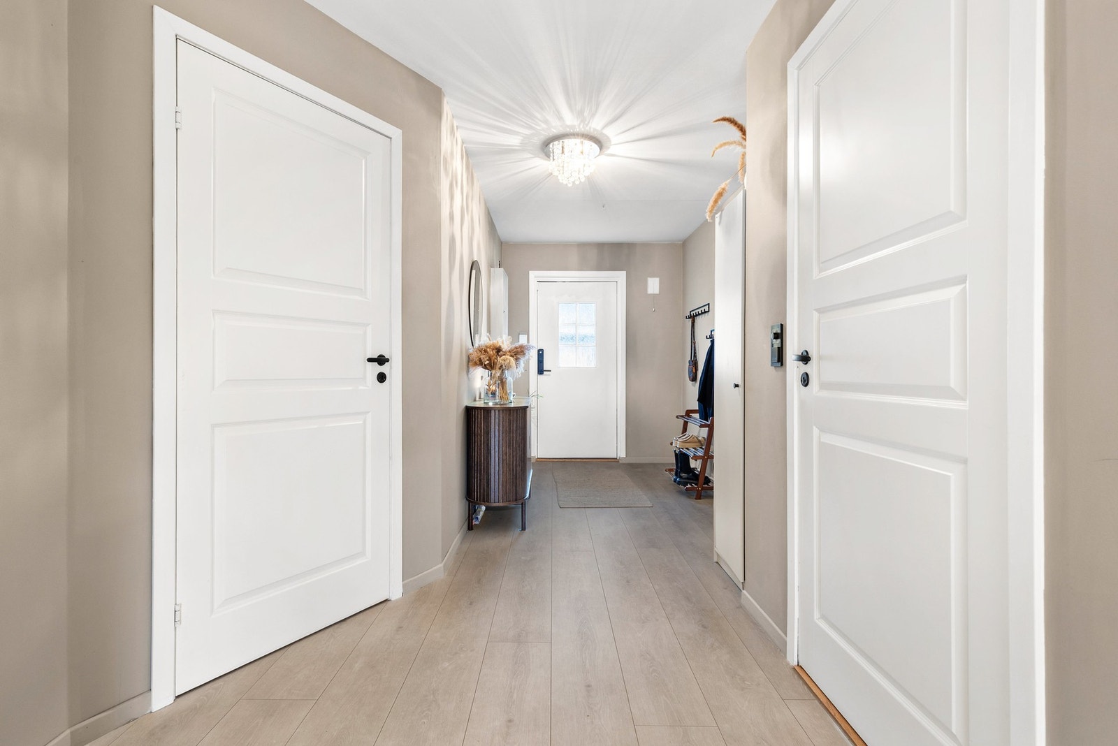 Lys og romslig entré med 1-stavs laminatgulv og slette flater på vegger og i himling Galleribilde