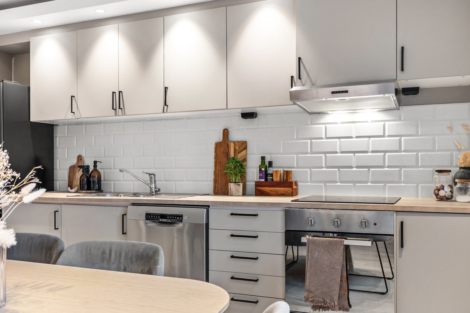 Det er montert kjøkkenventilator med avtrekk ut og vegg over benkeplate er flissatt Galleribilde