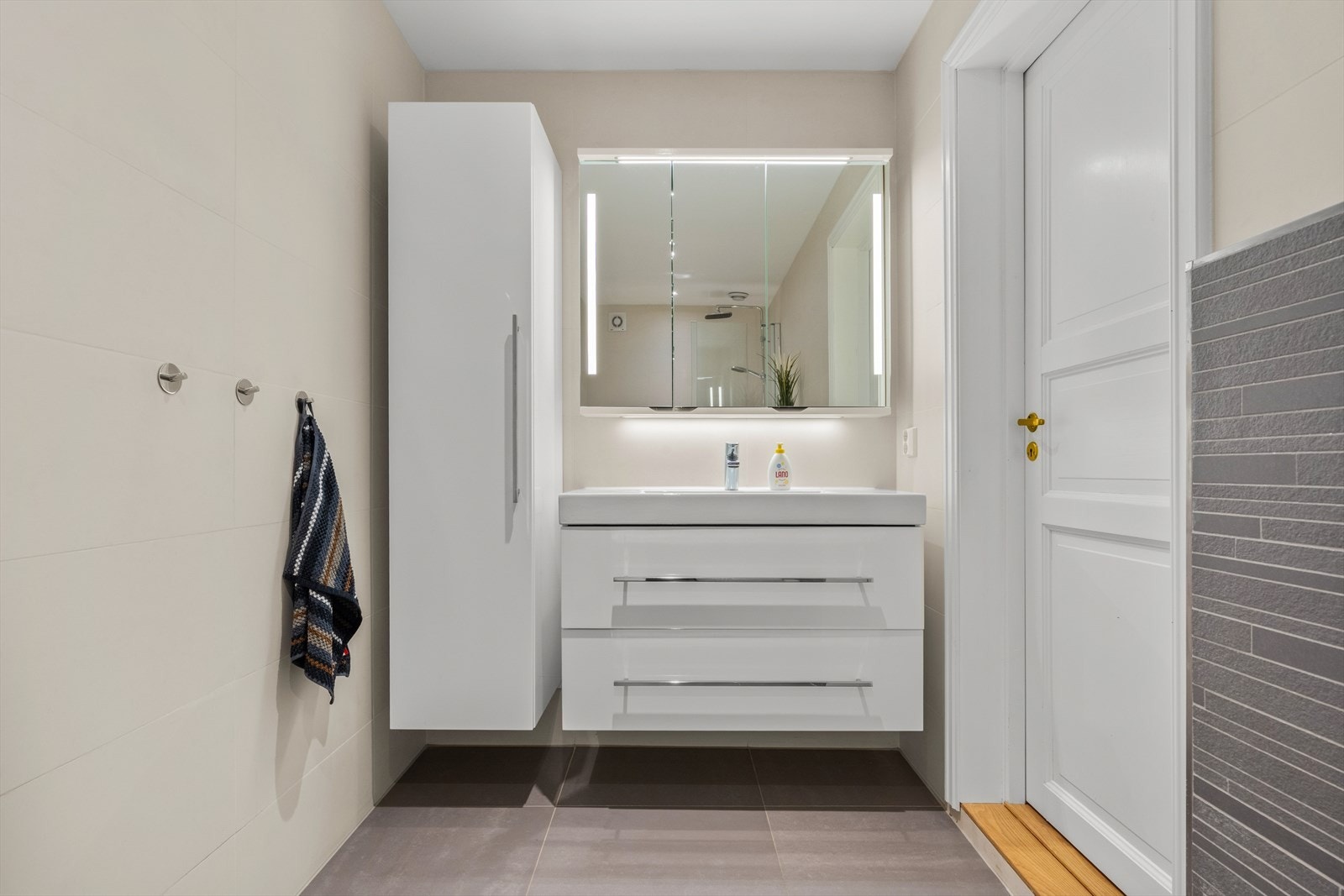 Badet har en praktisk baderomsinnredning som gir rikelig oppbevaringsplass. Galleribilde