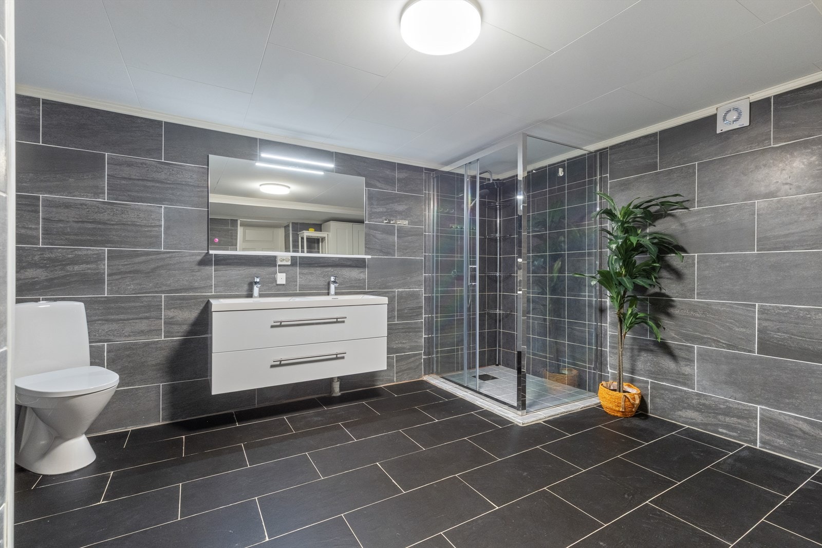 Lekkert flislagt og romslig bad med termostatstyrt varme i gulv. Badet ble renovert i 2019. Galleribilde