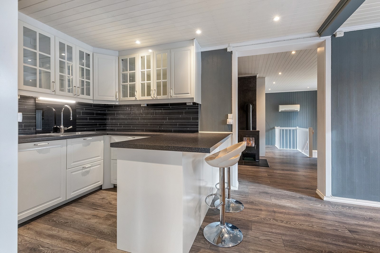 Kjøkkenet er i åpen løsning til spiseplassen, adskilt med et kjøkkenskap med benkeplate i en barløsning. Galleribilde