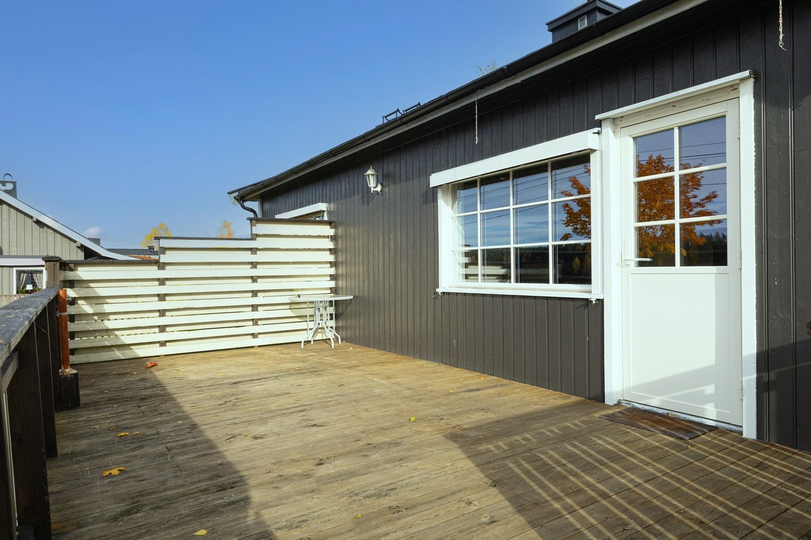 Terrasse mot vest med adkomst fra stue og terreng/hage, fundamentert på støpt betongvange, labenker og Leca-punkter. Gulv med beiset impregnerte terrassebord, malt rekkverk med håndløper. Målt gulvareal på 23m2. Galleribilde